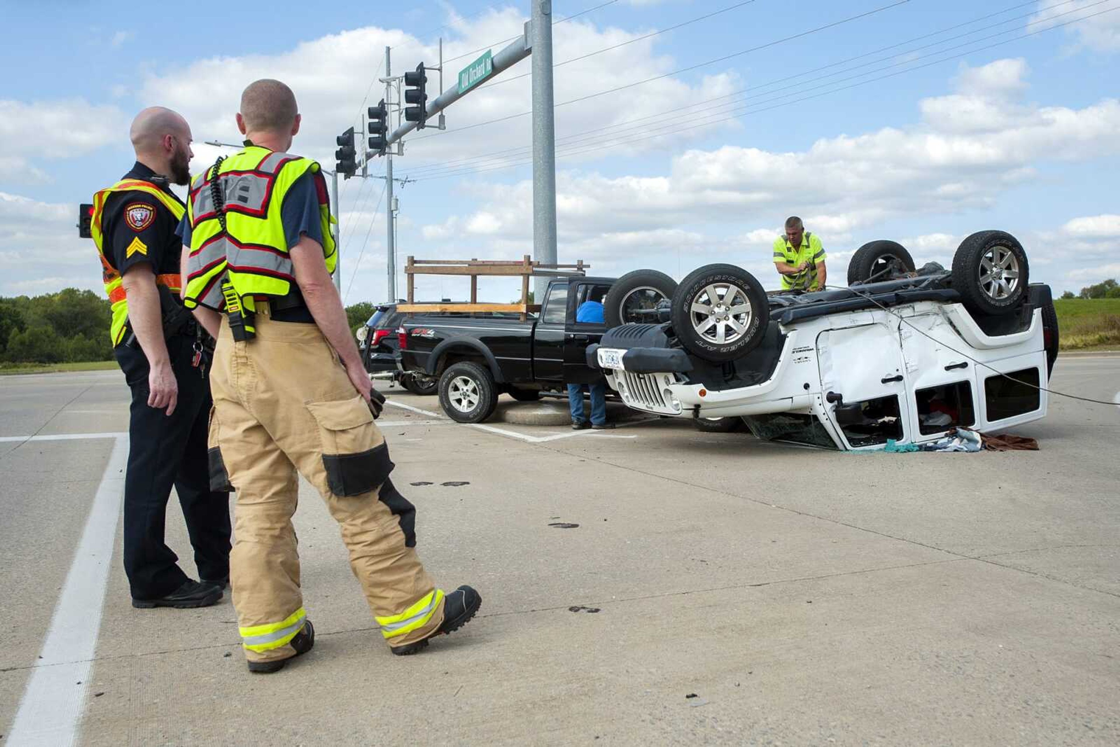 From left, Jackson police Sgt. Jason Wilhelm stands with Jackson fire Capt. Tyson Medlock as wrecking crews prepare to tow an overturned Jeep after a two-vehicle collision that occurred at 2:28 p.m. Monday near the intersection of East Main Street and Old Orchard Road in Jackson. Jackson police Lt. Alex Broch said one person was transported from the scene by ambulance and both vehicles were towed from the scene.