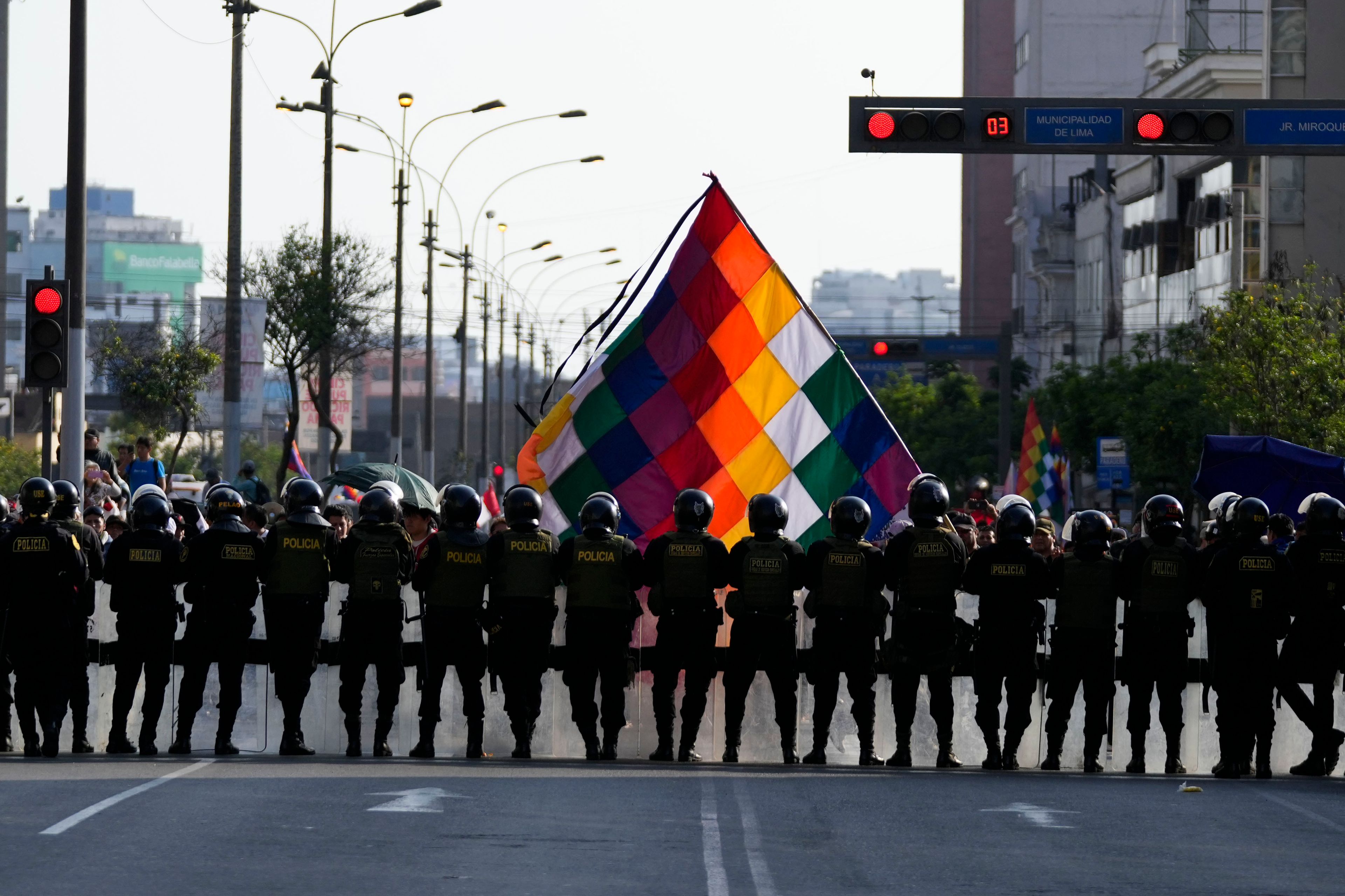 Police officers block anti-government protesters from making their way to Congress, on the sidelines of the Asia-Pacific Economic Cooperation (APEC) summit in Lima, Peru, Wednesday, Nov. 13, 2024. (AP Photo/Fernando Vergara)