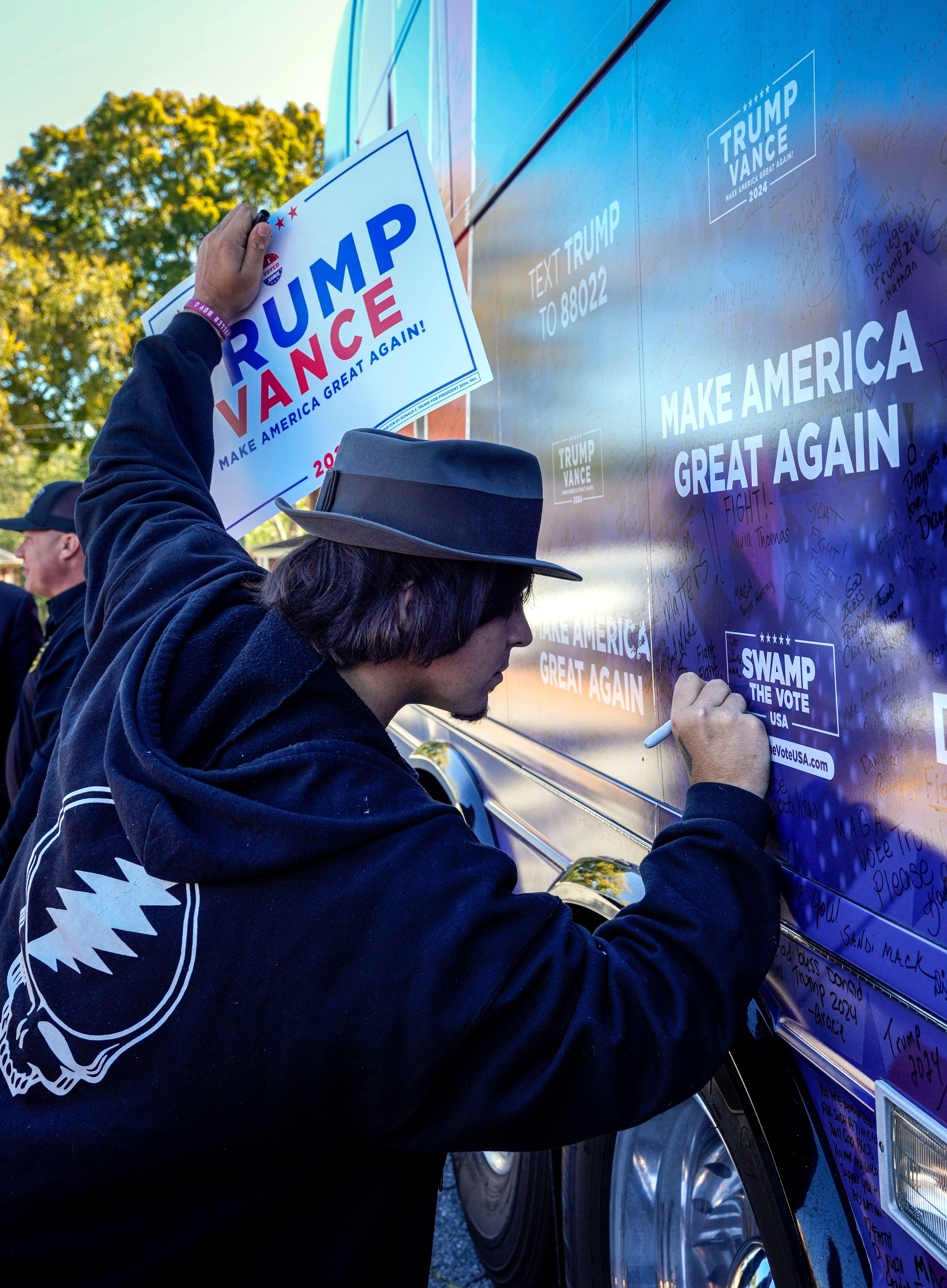 Former President Trump supporter, Tyler Schultz of Rutherfordton signs the tour bus during the Team Trump bus tour across North Carolina, Thursday, Oct. 17, 2024 in Rutherfordton, N.C. (AP Photo/Kathy Kmonicek)