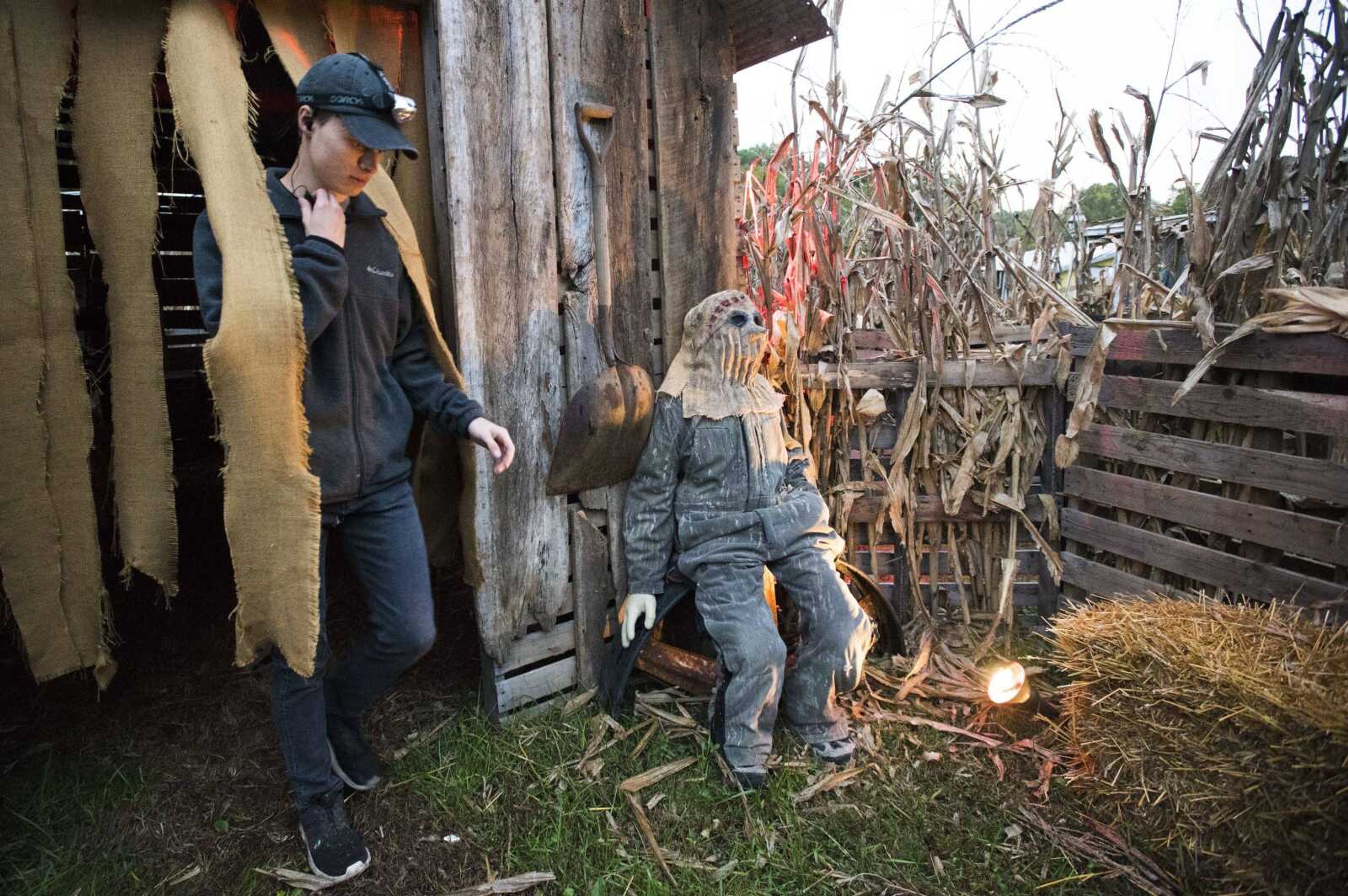 ABOVE: Tyler Macke talks to a coworker over walkie talkie at Black Forest Haunted Ghost Town before opening the attraction to guests for the evening. TOP RIGHT: Black Forest owner Greg Macke has his face painted before serving as one of the Black Forest Haunted Ghost Town grim reapers. BOTTOM RIGHT: The butcher's shop is shown