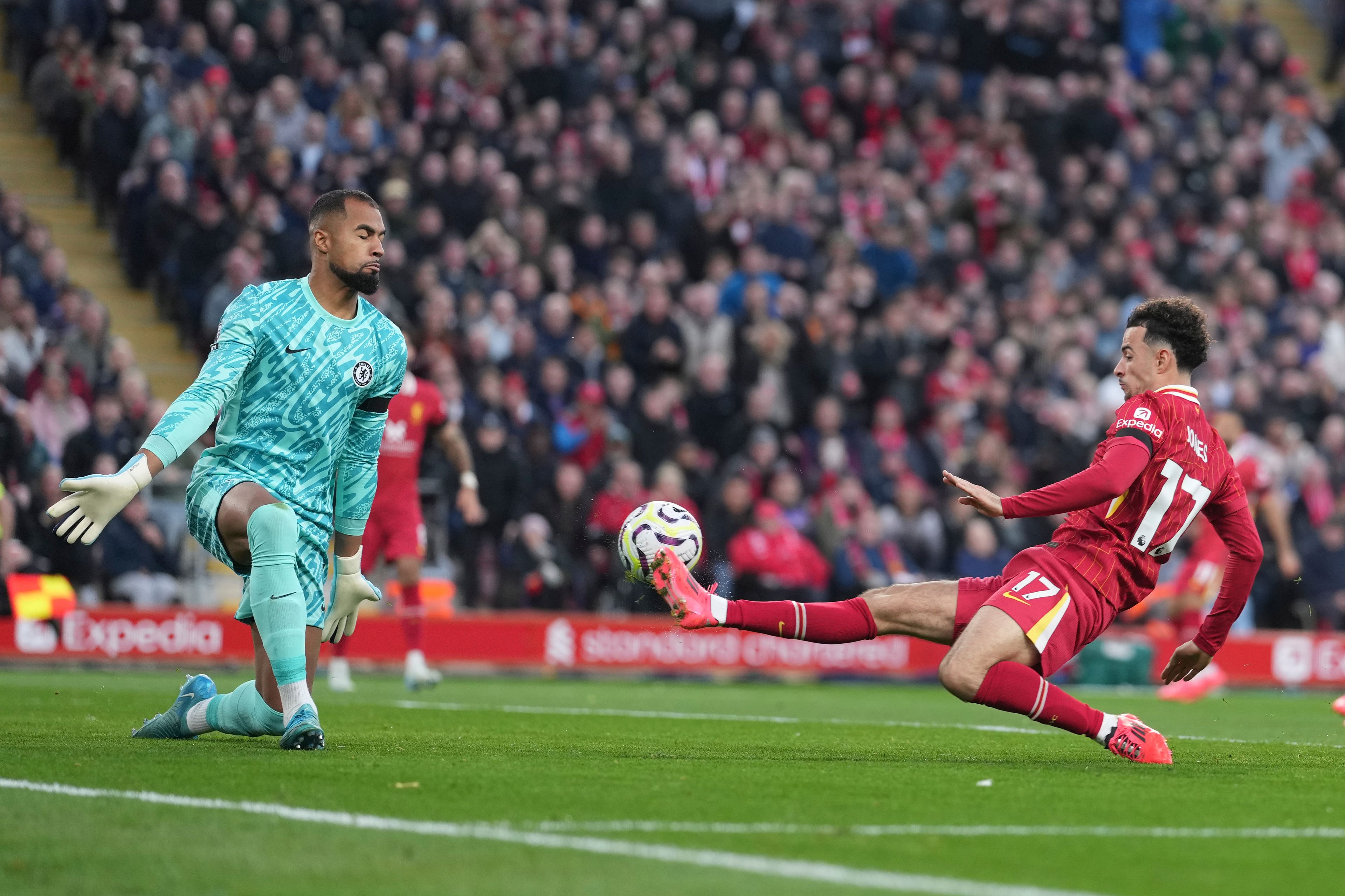 Liverpool's Curtis Jones, right, scores his side's second goal past Chelsea's goalkeeper Robert Sanchez during the English Premier League soccer match between Liverpool and Chelsea at Anfield Stadium, Liverpool, England, Sunday, Oct. 20, 2024. (AP Photo/Jon Super)