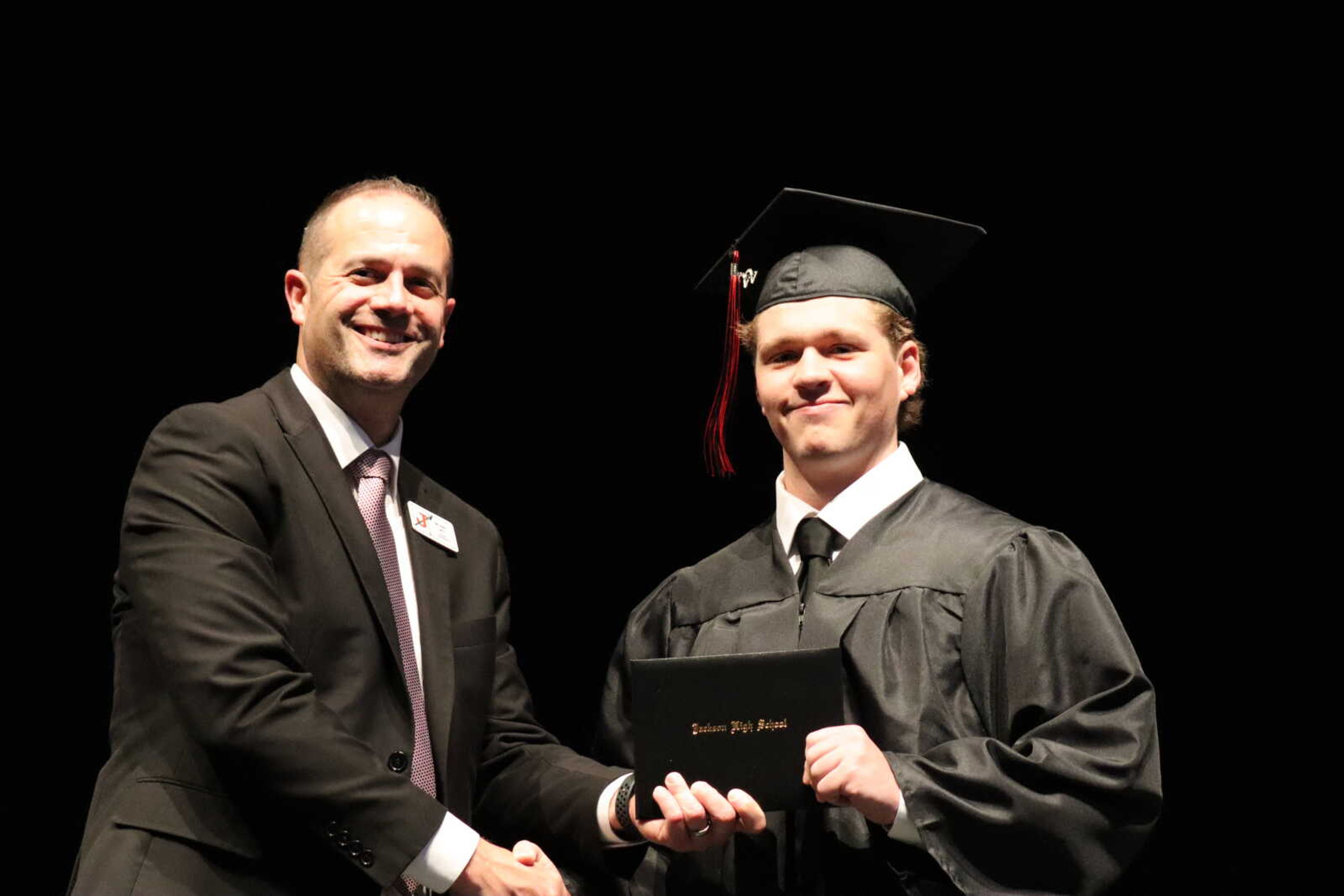 A graduate poses with his new diploma.