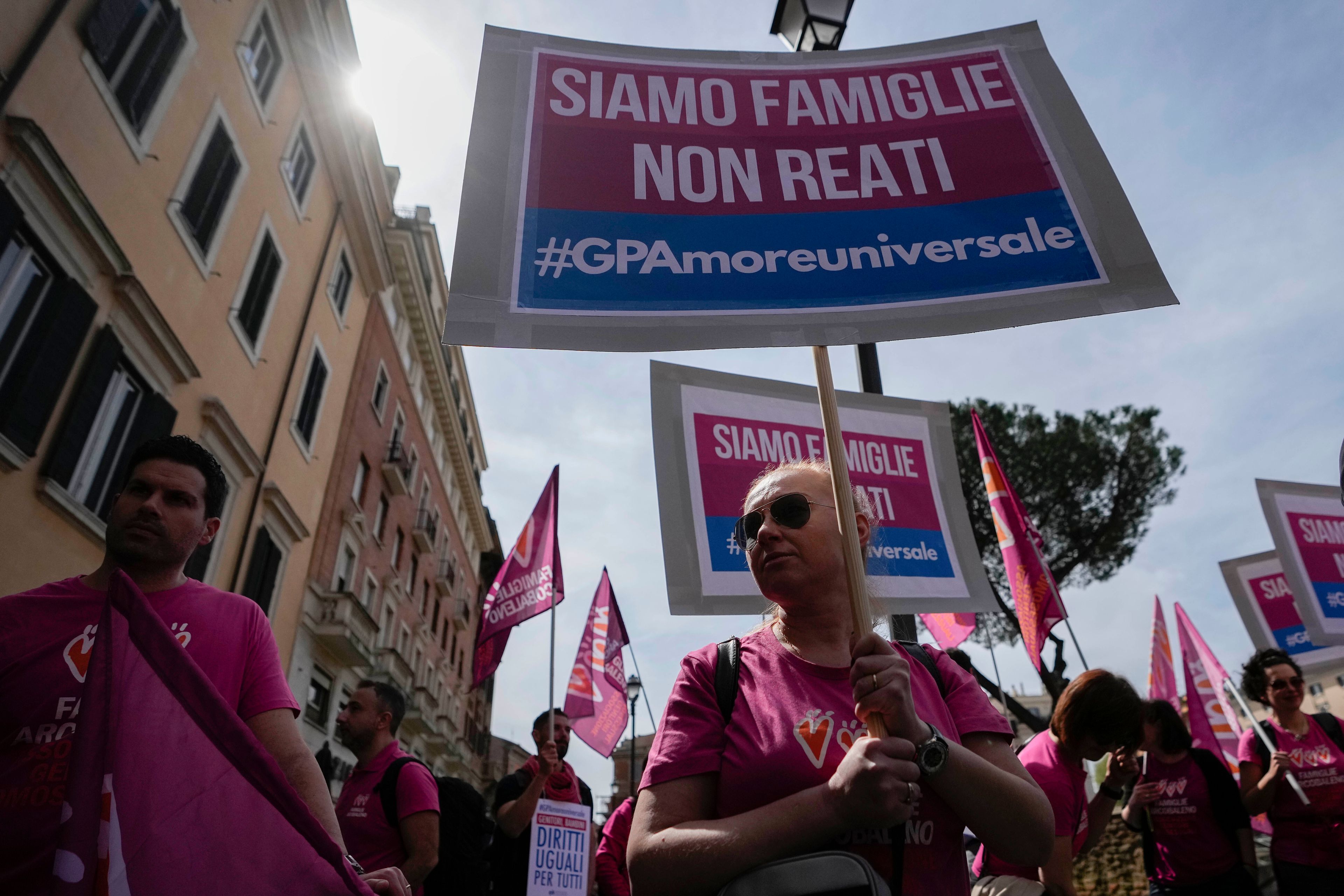 FILE - People hold banners reading "we are families not crimes" during a pro-surrogacy flash-mob in Rome, April 5, 2024. (AP Photo/Alessandra Tarantino, File)