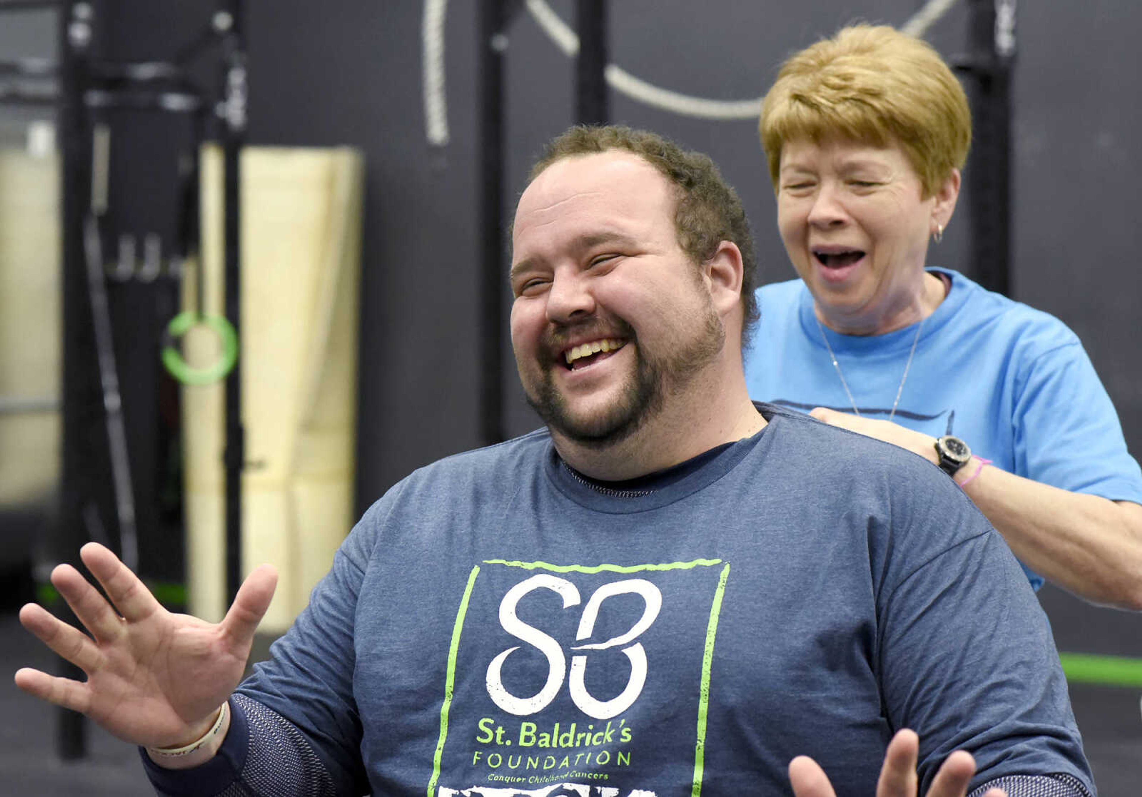 Joe Moss laughs as Jean McLane prepares to shave his head on Saturday, March 4, 2017, during the St. Baldrick's Foundation fundraiser at Old Orchard CrossFit in Jackson.