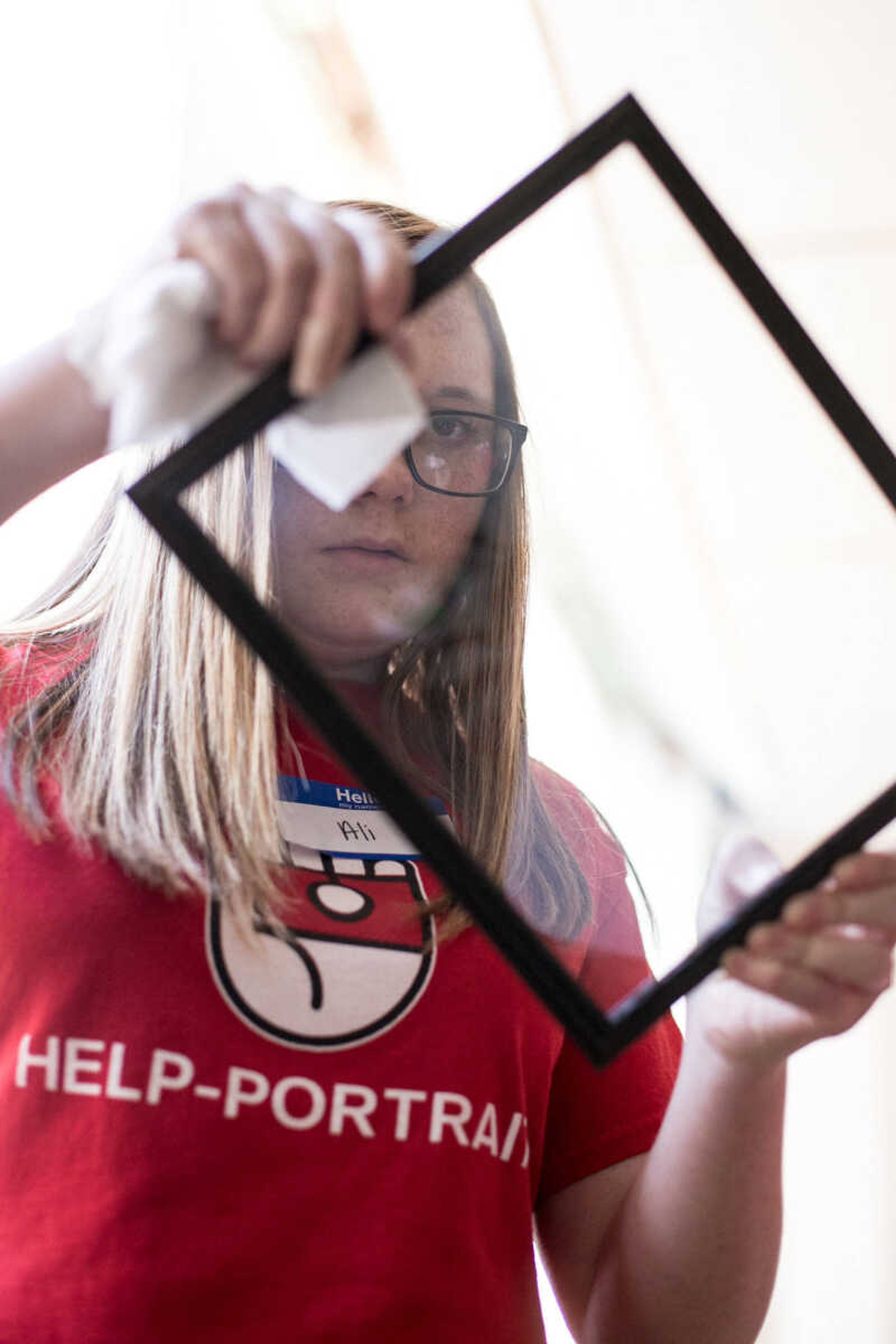 GLENN LANDBERG ~ glandberg@semissourian.com

Ali Keillor wipes a frame clean in preparation for framing a family photos taken during the Help-Portrait event at the House of Hope Saturday, Dec. 5, 2015 in Cape Girardeau.