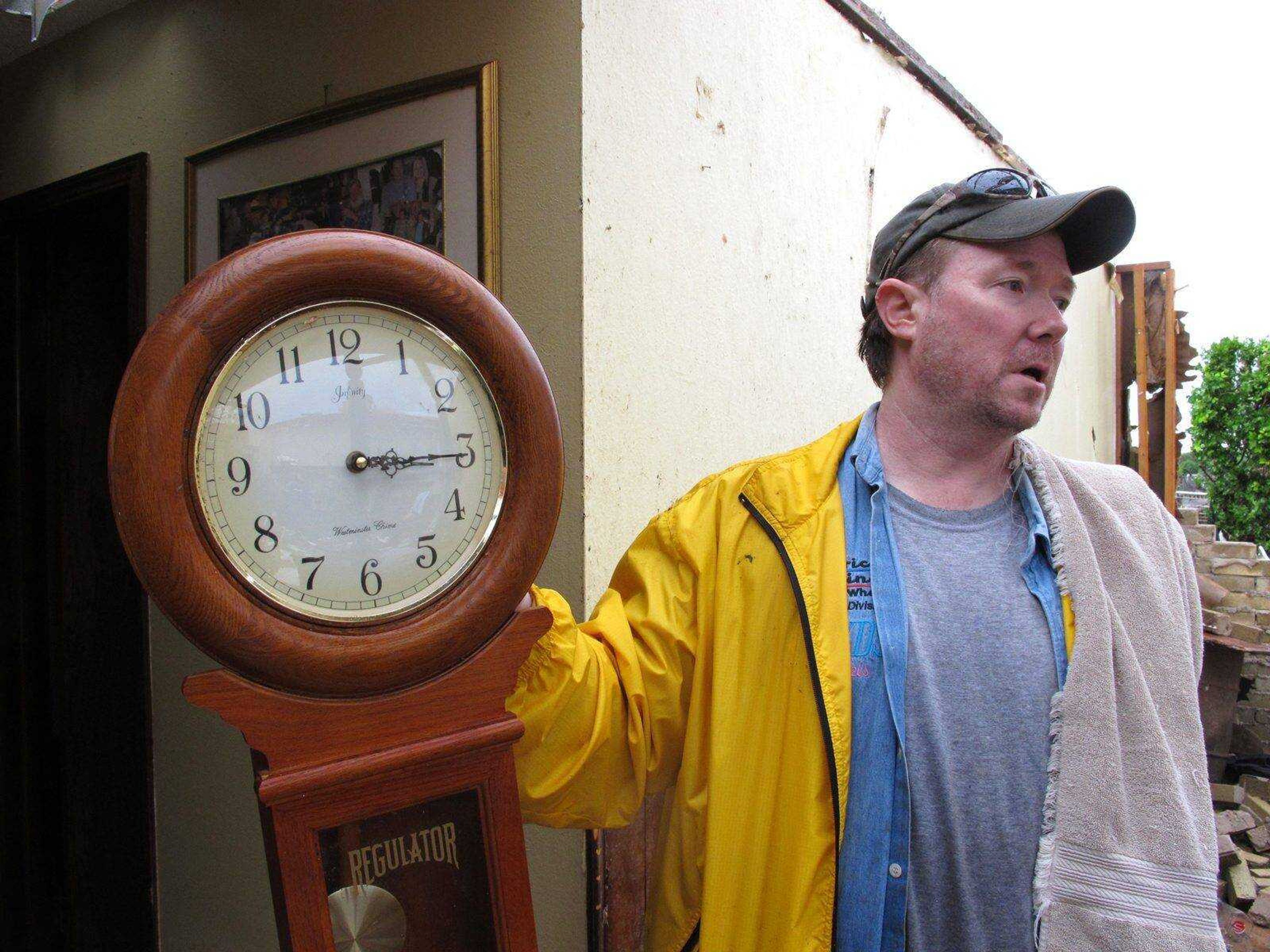 Kevin Metz holds up a stopped clock he found in the rubble of his father&#8217;s home Tuesday in Moore, Okla. Monday&#8217;s EF5 tornado destroyed Wayne Osmus&#8217; home and much of the Oklahoma City suburb. (Allen Breed ~ Associated Press)