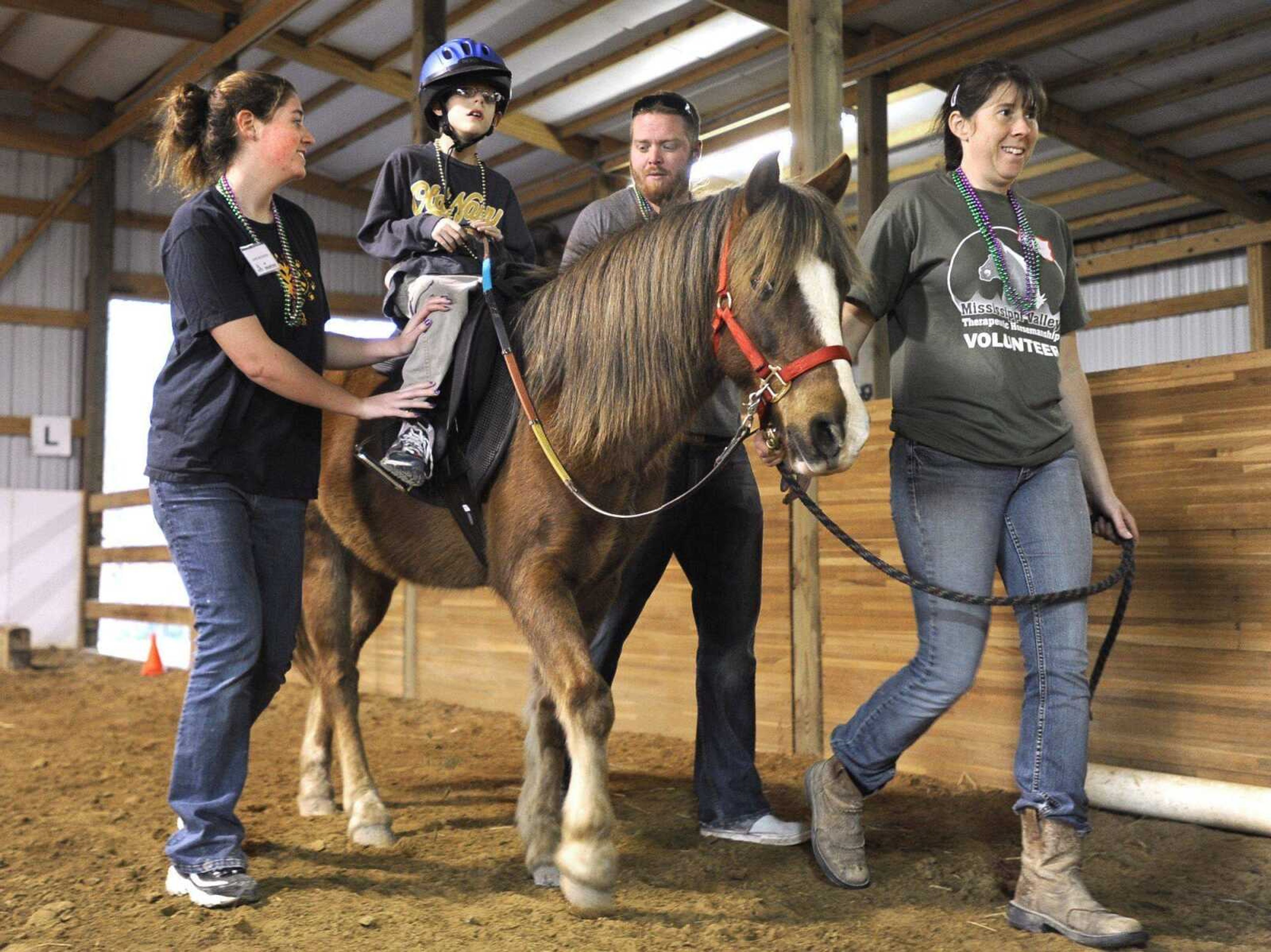 Landon Southard rides Bo, a Welsh pony, with assistants Jane Mattione, left, Quinn Strong and Varina Luttrell during a lesson Thursday with Mississippi Valley Therapeutic Horsemanship. (Fred Lynch)