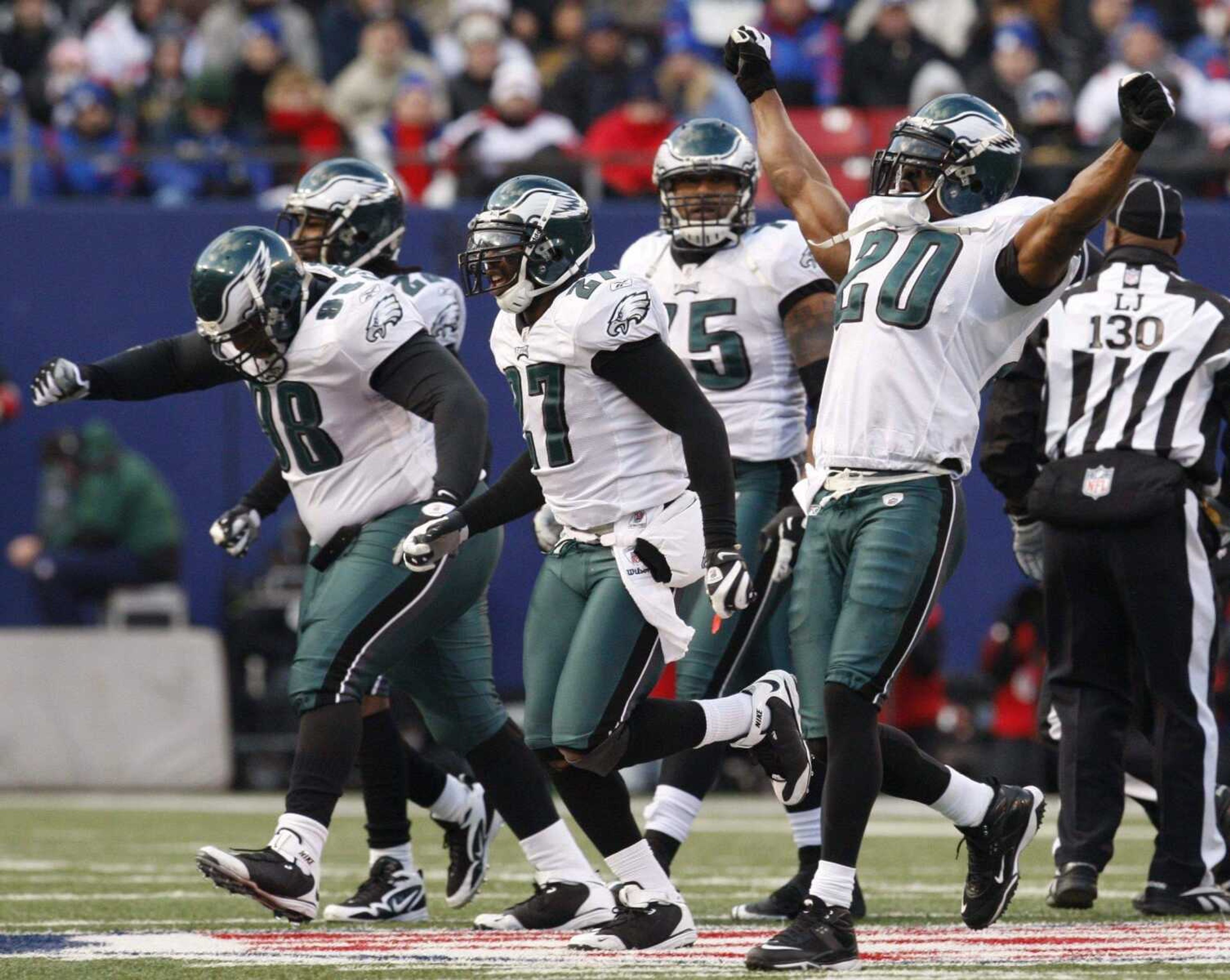 KATHY WILLENS ~ Associated PressPhiladelphia Eagles' Brian Dawkins (20), Quintin Mikell (27) and Mike Patterson (98) celebrate after stopping the New York Giants on a fourth-down play during the fourth quarter of their NFC divisional playoff football game Sunday in East Rutherford, N.J. The Eagles won 23-11.