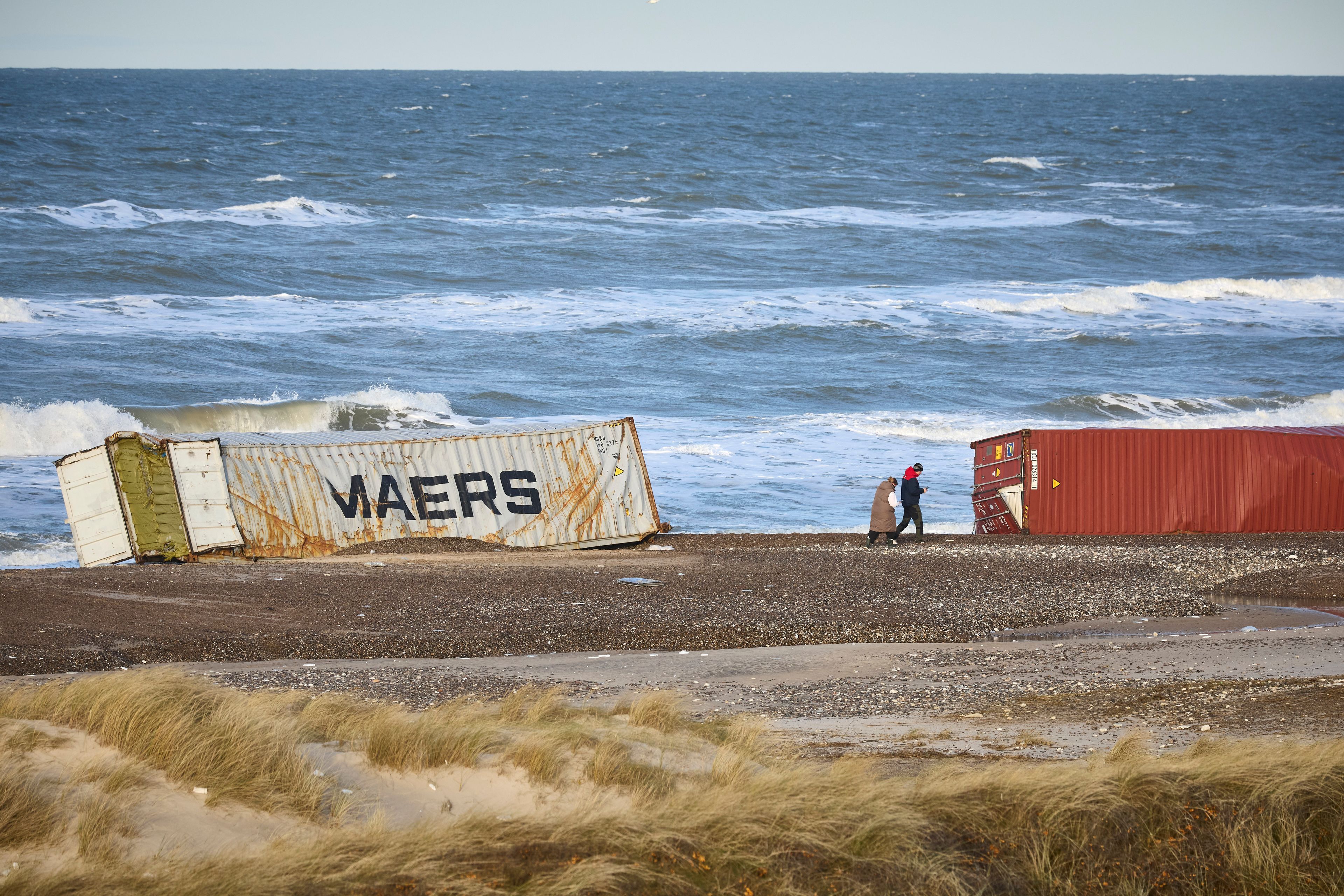 FILE - People walk past stranded containers in the area between Tranum and Slette beach in Denmark, Saturday, Dec. 23, 2023, a day after a Maersk ship dropped 46 containers off the coast between Bulbjerg and Svinkloev in the northwestern part of Jutland, during storm Pia. (Claus Bjoern Larsen/Ritzau Scanpix via AP, File)