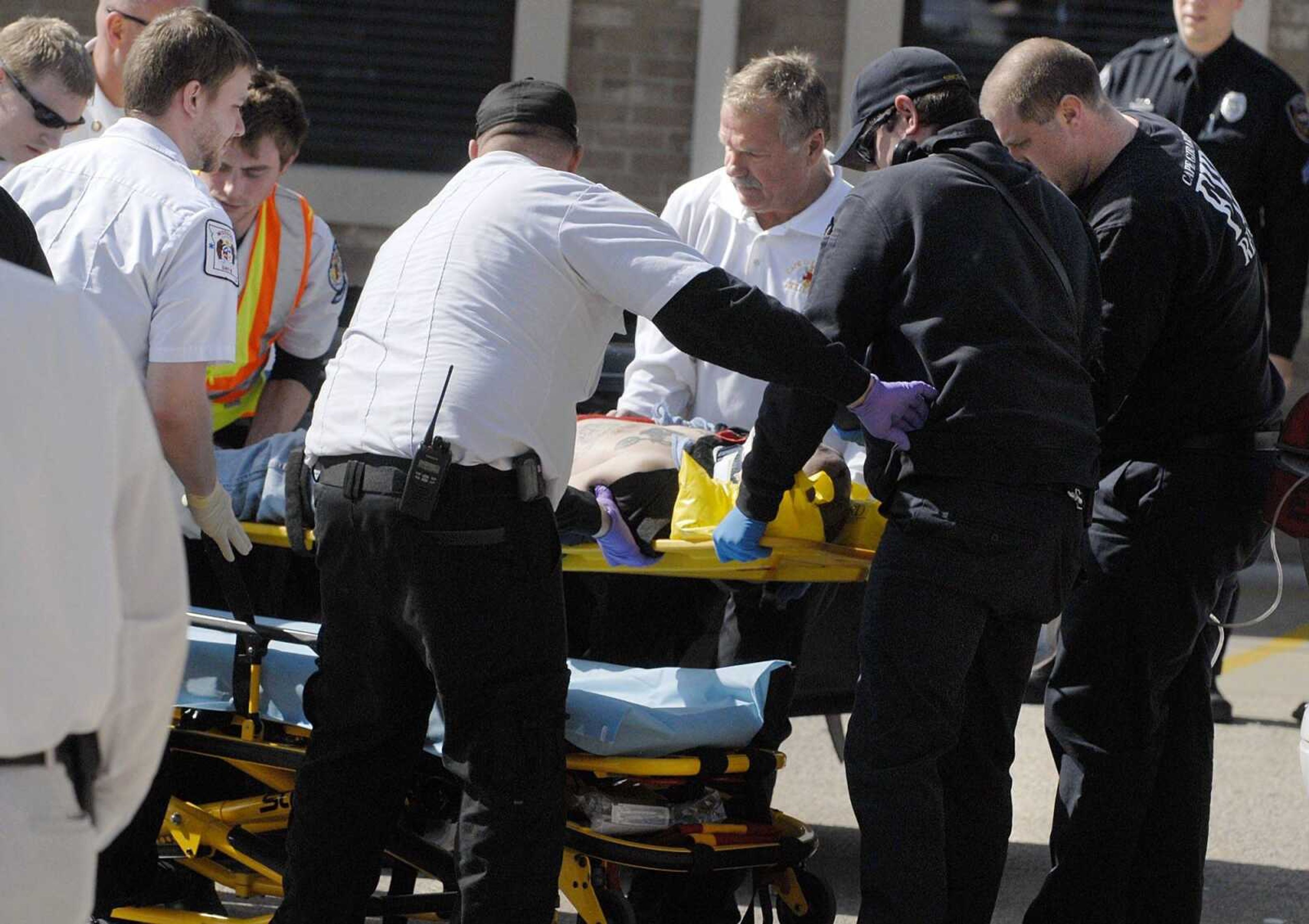 Cape Girardeau emergency responders work on a victim of a self-inflicted gun shot wound outside Dan's Key and Lock Tuesday afternoon, March 6, 2012. Police say the man is a suspect in a Sunday assault along Cape LaCroix Recreational Trail. (Laura Simon)