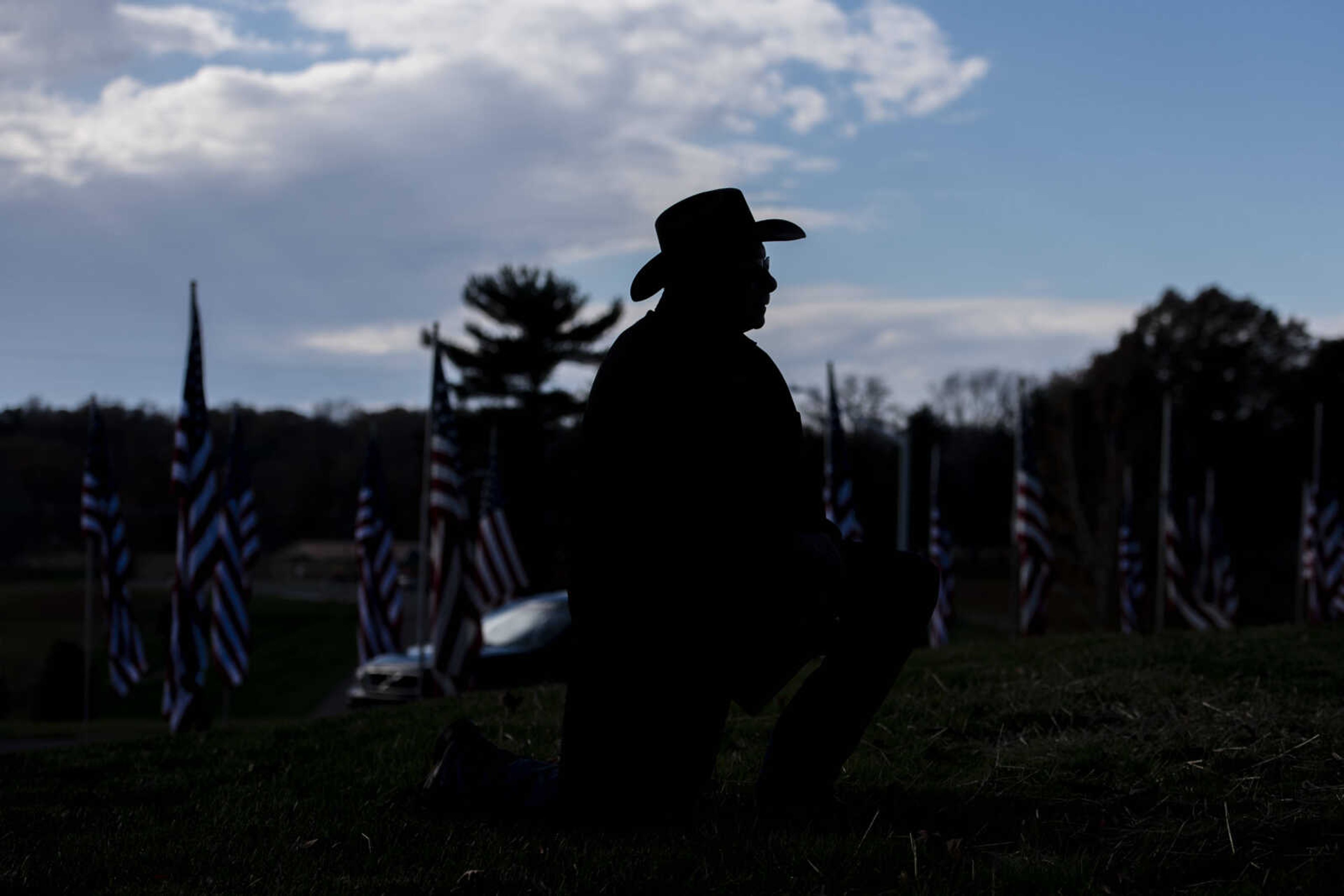 Rick Sinclair kneels and listens at the Veterans Day Ceremony Sunday, Nov. 11, 2018, at North County Park in Cape Girardeau.