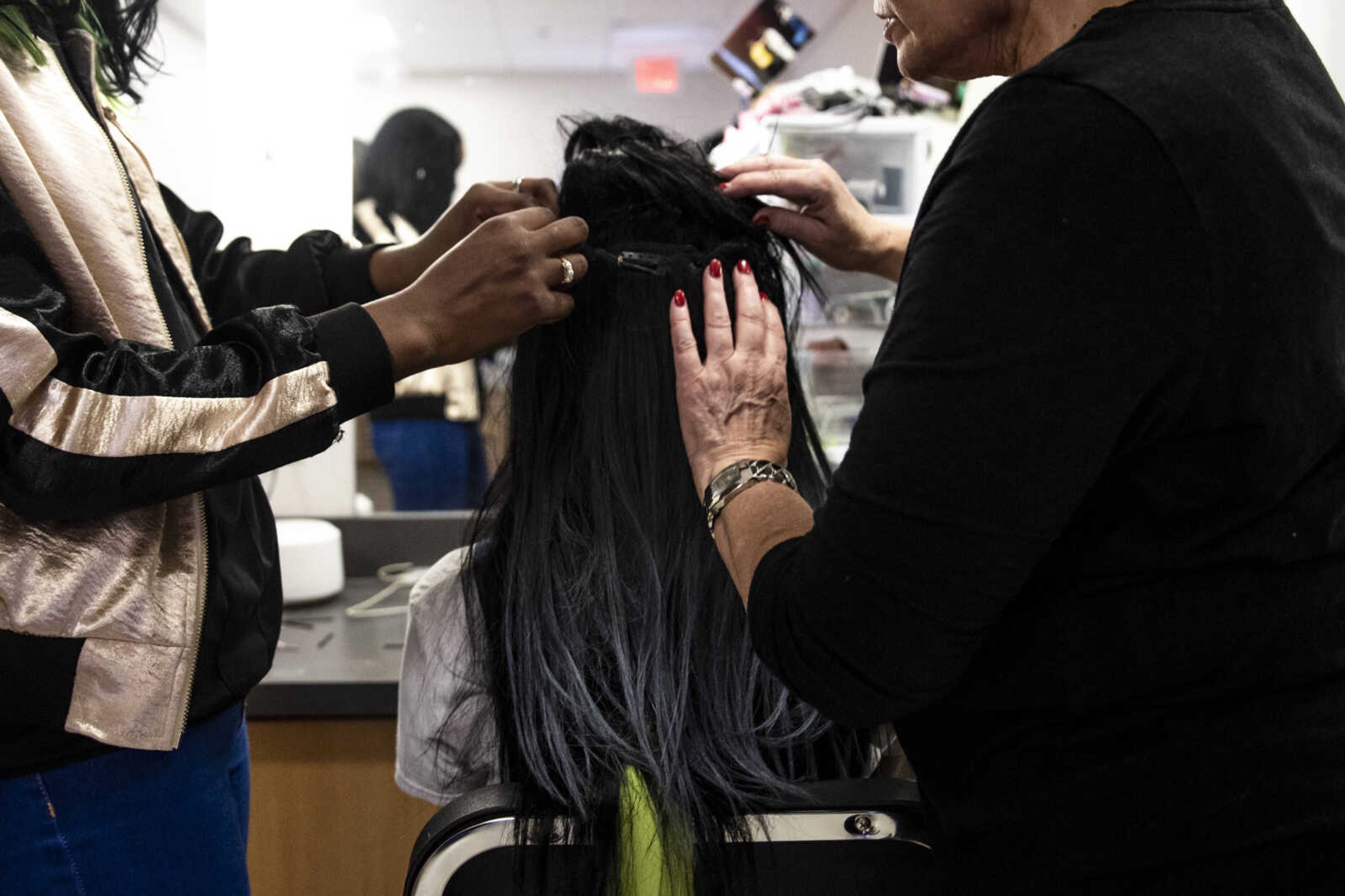 Peighton Robinson, center, prepares for her role of Donna Sheridan and sits while hair extensions are put in her hair by Dina Martin, left, and "Mimi," right, during the media night of Cape Central High School's spring musical production of "Mamma Mia!" Wednesday, April 10, 2019, in Cape Girardeau.