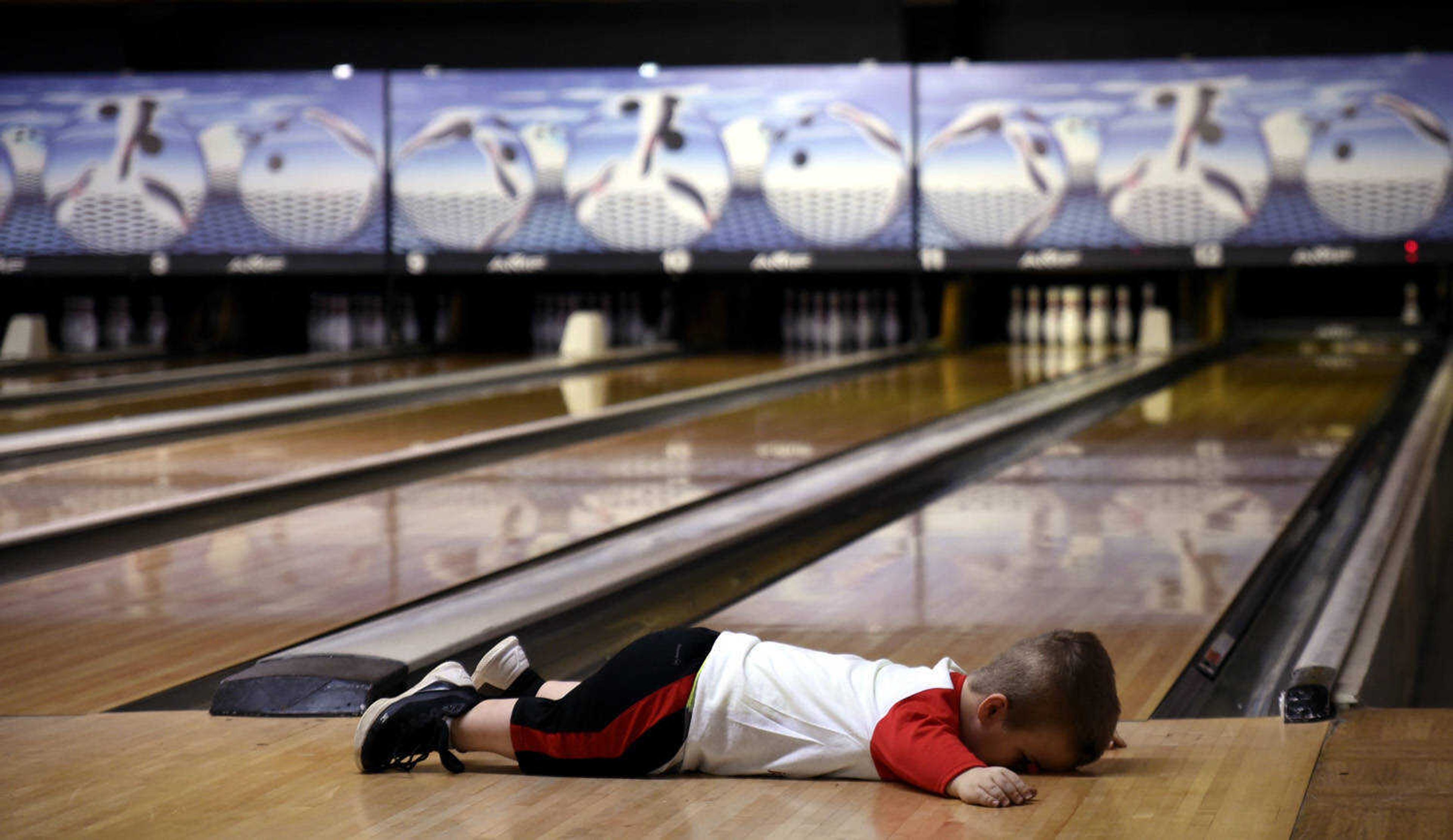 Izaac Pursley lays face-down after missing a single pin, failing to make a strike, while bowling at Jackson Lanes March 19, 2018, in Jackson.