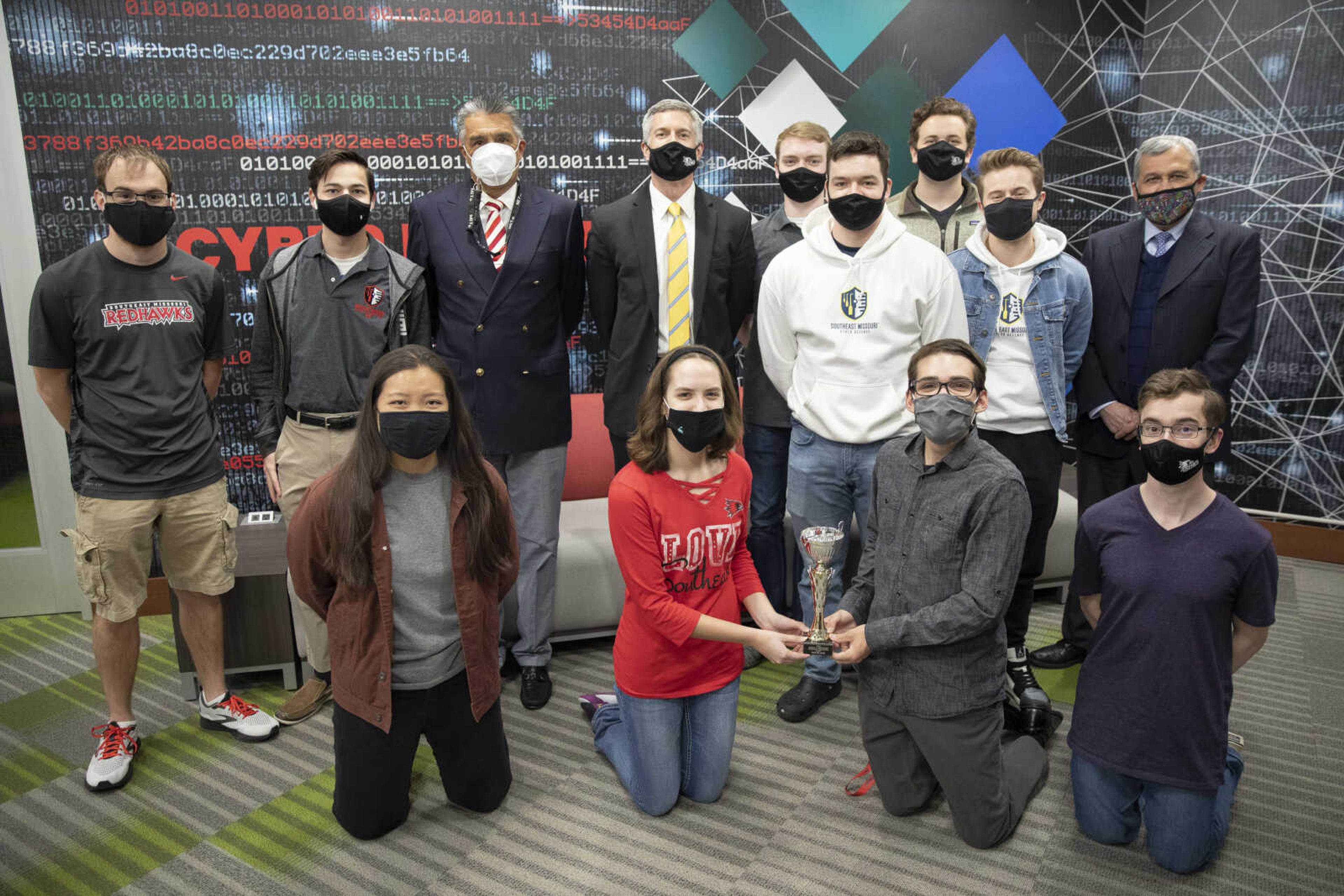 The Southeast Missouri State University Cyber Defense Team members pose for a photo with their third-place trophy win in the virtual 2021 Erich J. Spenger Midwest Regional Collegiate Cyber Defense Competition on Tuesday. Back row, from left, Gabe Stier and Jack Gavin, team co-captains; Mario Alberto Garcia, director of the university's Cybersecurity Institute and the team's adviser; Southeast provost Mike Godard; team members Elijah Iverson, Joseph Kossack, Stephen Gullette and Christopher Atkins; and Alberto Davila, dean of the Donald L. Harrison College of Business and Computing. Front row, from left, team members Jennifer Tenholder, Suzie Luehmann and Luke Skaggs.