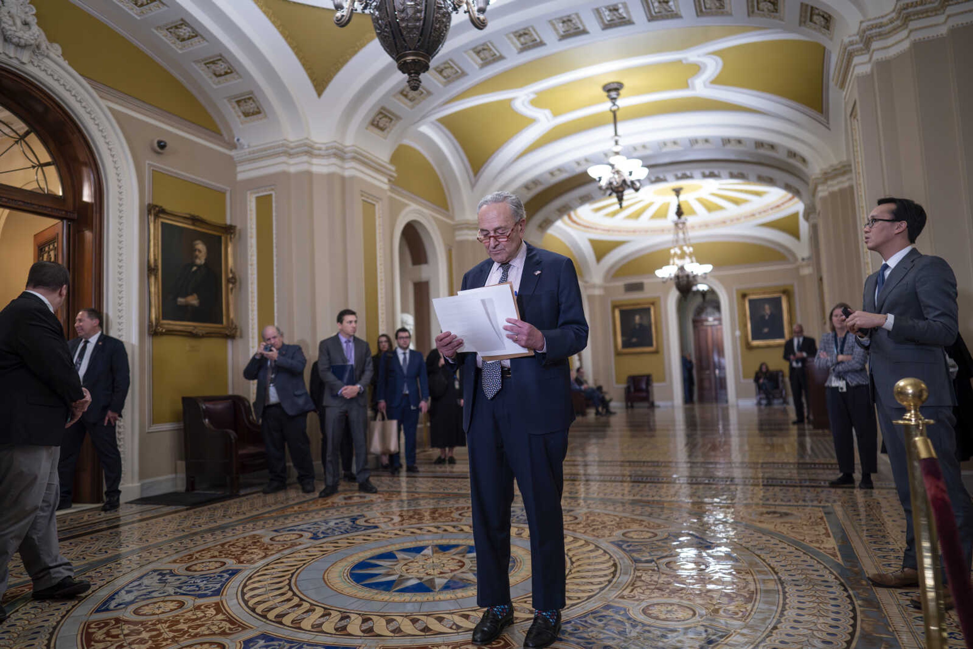 Senate Majority Leader Chuck Schumer, D-N.Y., checks his notes before speaking to reporters about support for Israel following a closed-door caucus meeting Tuesday at the Capitol in Washington.