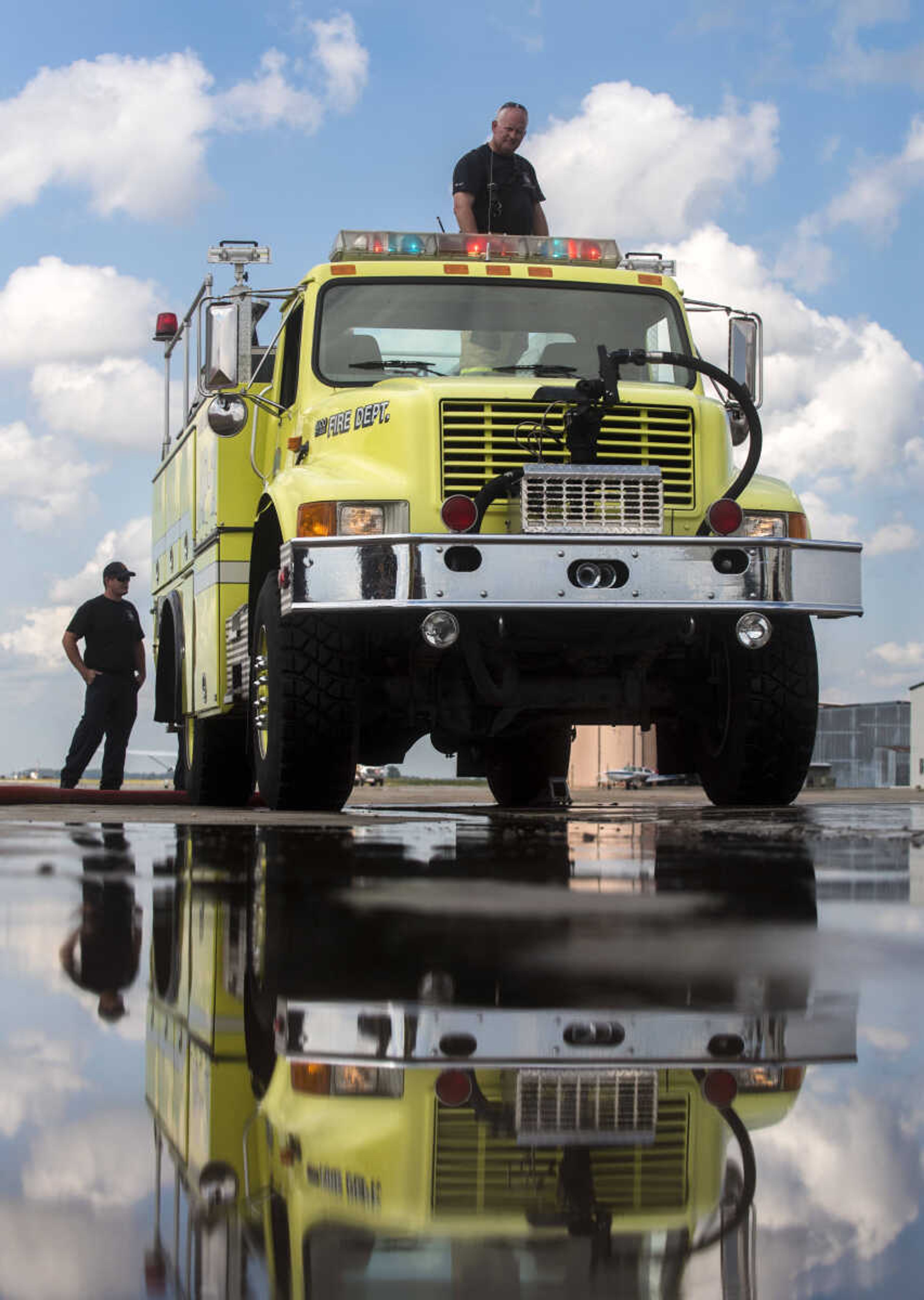 Firefighter Larry Hagan stands on top of a fire truck while it is refilled with water used for airplane fire drills at the Cape Girardeau Regional Airport Friday morning, Sept. 15, 2017 in Cape Girardeau.