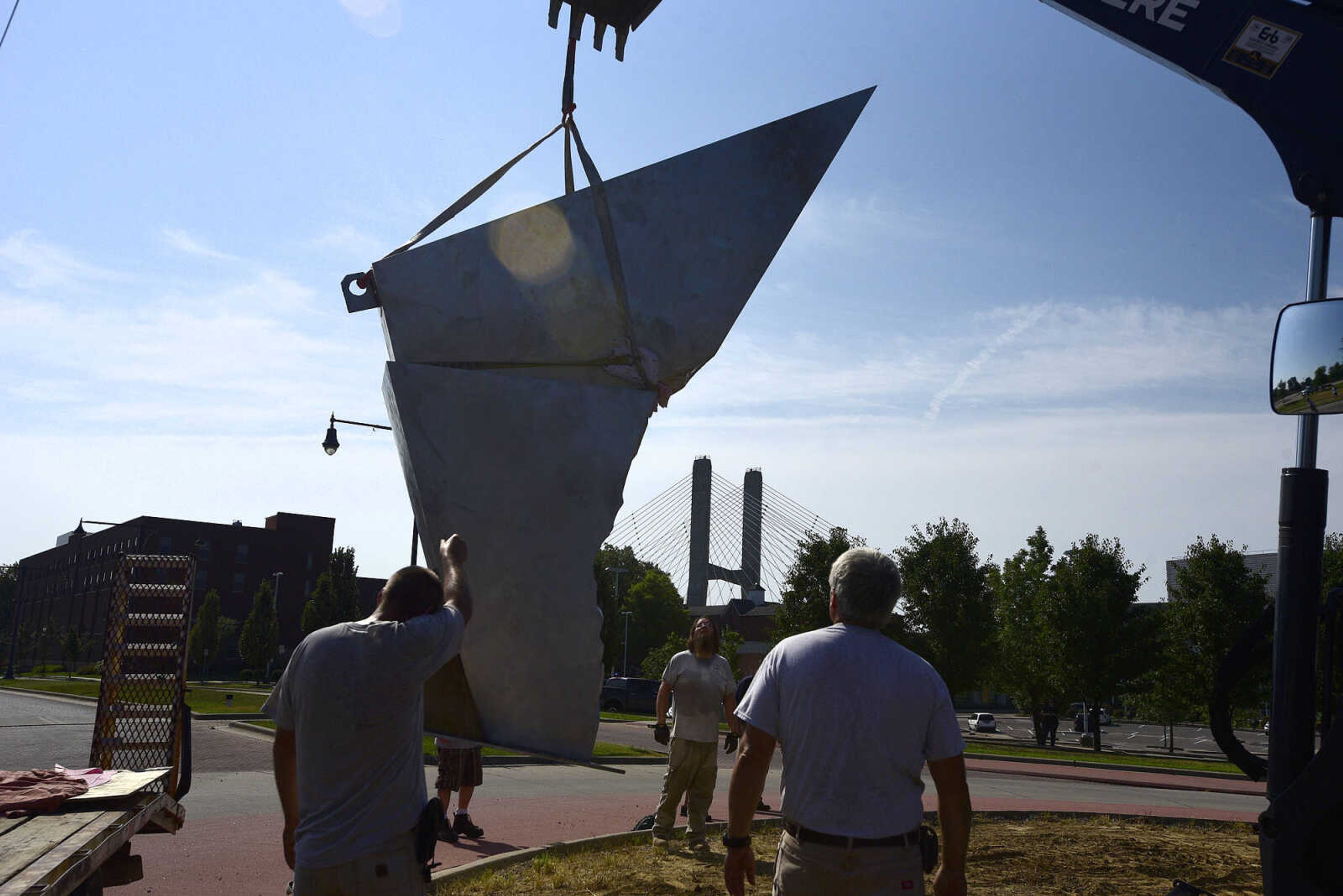 Cape Girardeau Parks and Recreation employees install the second piece of Chris Wubbena's 14-foot sculpture, "Commence", in the Fountain Street roundabout on Monday, July 24, 2017, near the River Campus in Cape Girardeau.