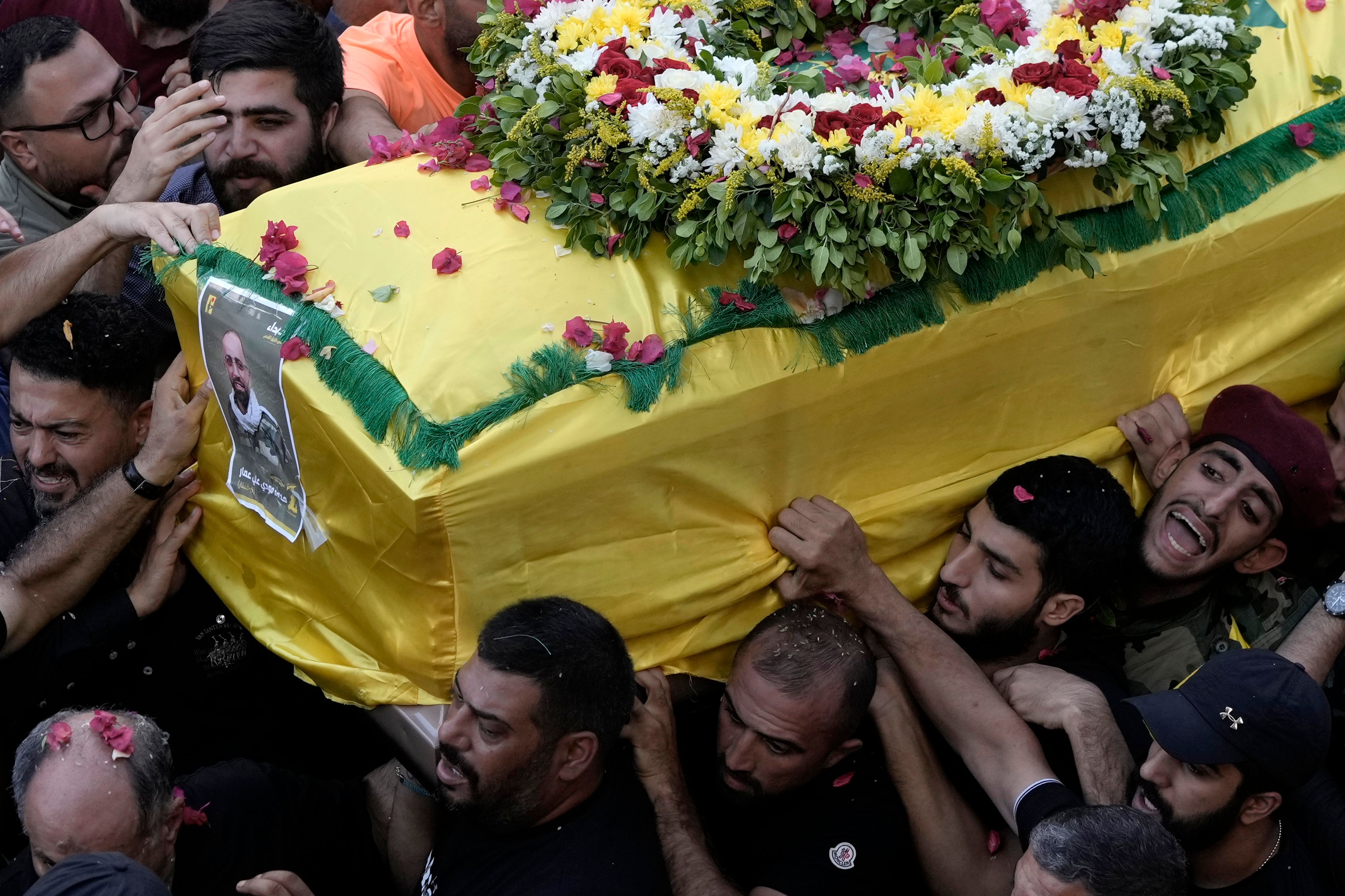 Hezbollah fighters carry one of the coffins of four fallen comrades who were killed Tuesday after their handheld pagers exploded, in the southern suburb of Beirut, Lebanon, Wednesday, Sept. 18, 2024. (AP Photo/Bilal Hussein)