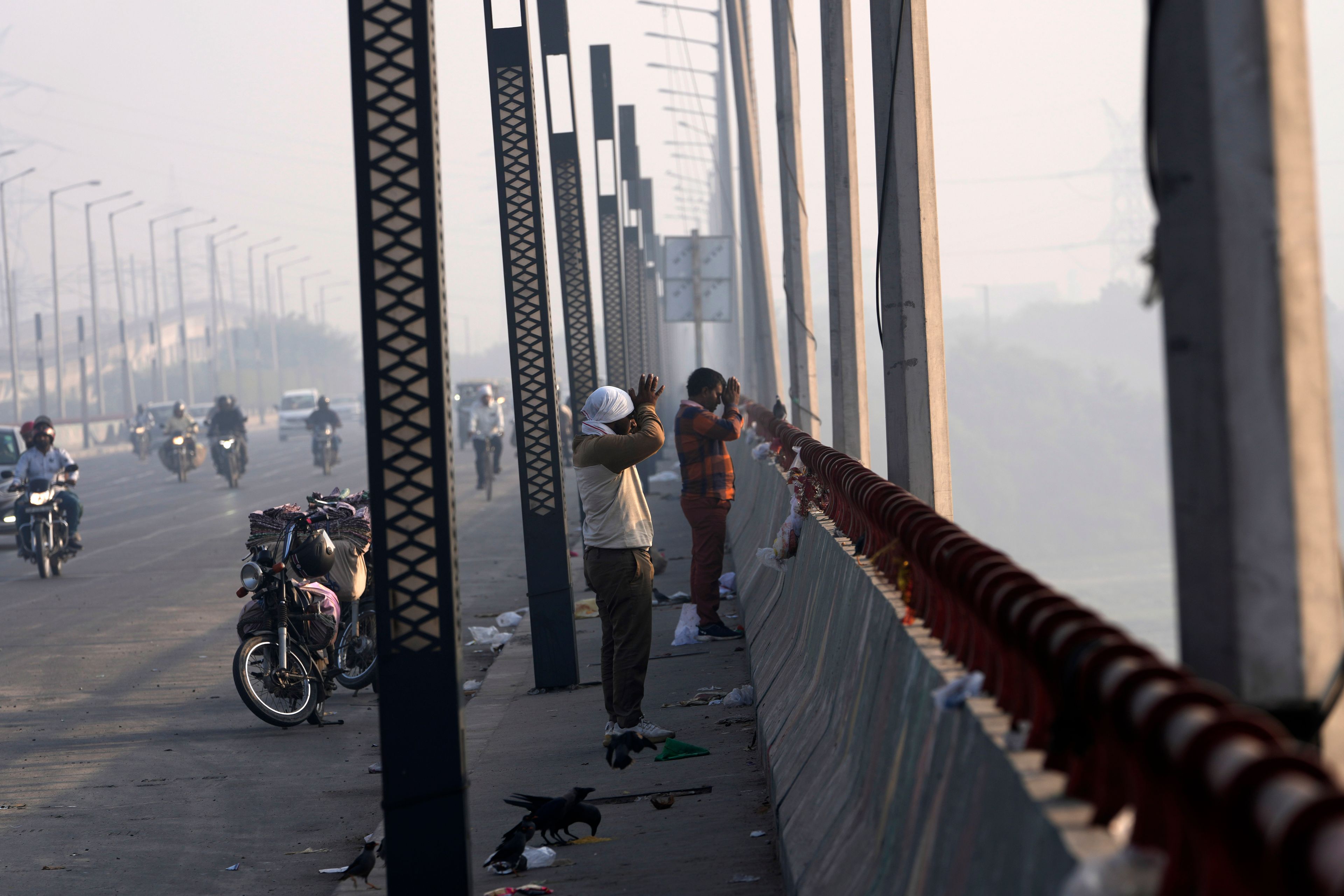 Commuters pray from a bridge across the river Yamuna in New Delhi, India, Tuesday, Oct. 29, 2024. (AP Photo/Manish Swarup)