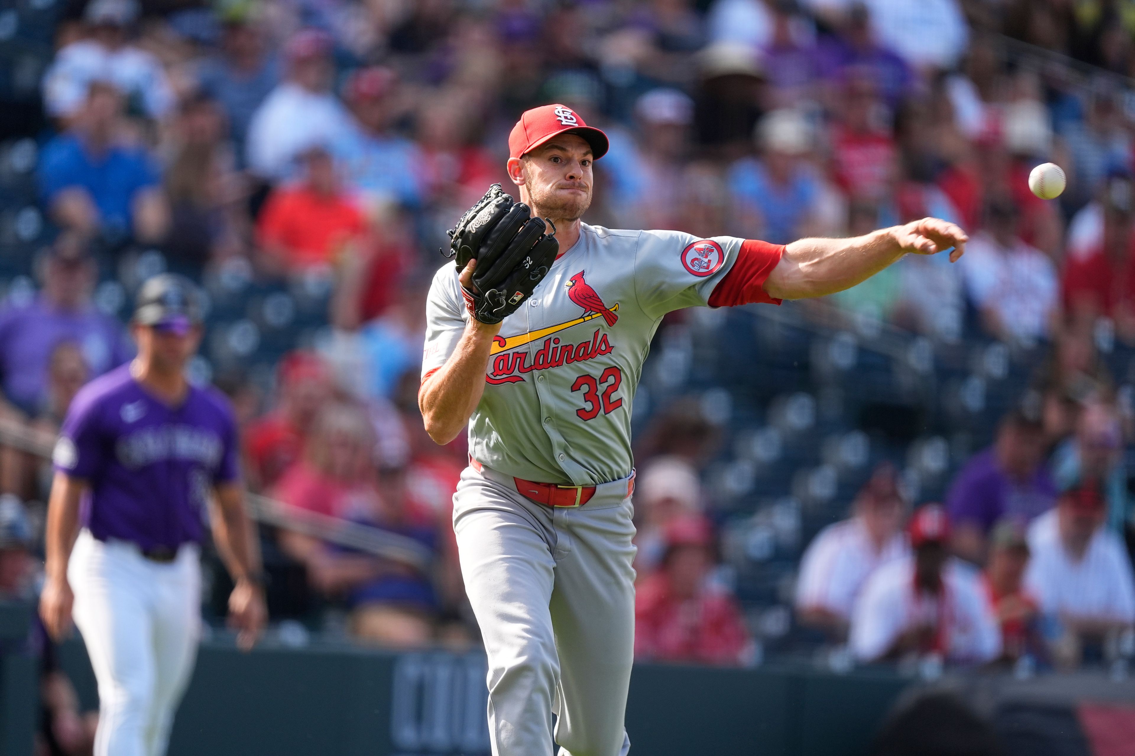 St. Louis Cardinals relief pitcher Steven Matz (32) throws to first base to put out Colorado Rockies' Jake Cave in the sixth inning of a baseball game Thursday, Sept. 26, 2024, in Denver. (AP Photo/David Zalubowski)