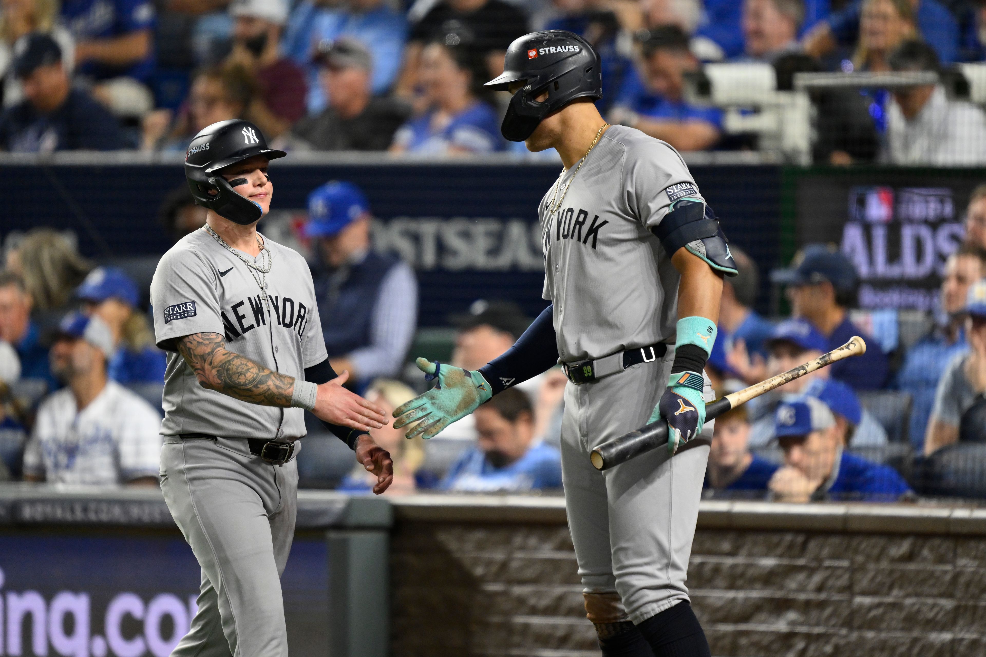 New York Yankees' Alex Verdugo, left, is congratulated by teammate Aaron Judge after scoring during the fifth inning in Game 4 of an American League Division baseball playoff series against the Kansas City Royals Thursday, Oct. 10, 2024, in Kansas City, Mo. (AP Photo/Reed Hoffmann)