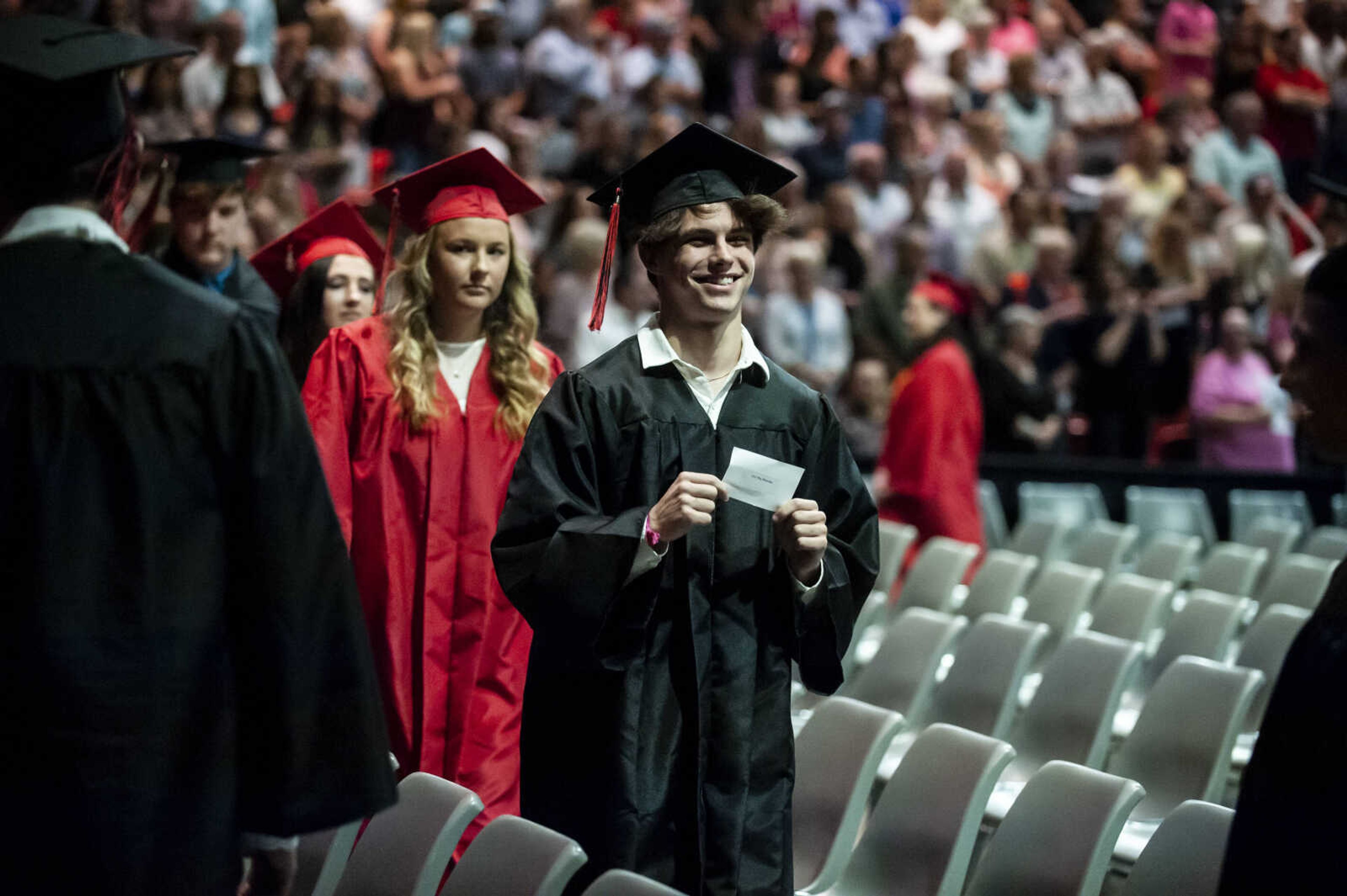 Levi Brandes walks to his assigned seat while holding up his name card during the Jackson High School Class of 2019 Commencement at the Show Me Center Friday, May 24, 2019, in Cape Girardeau.