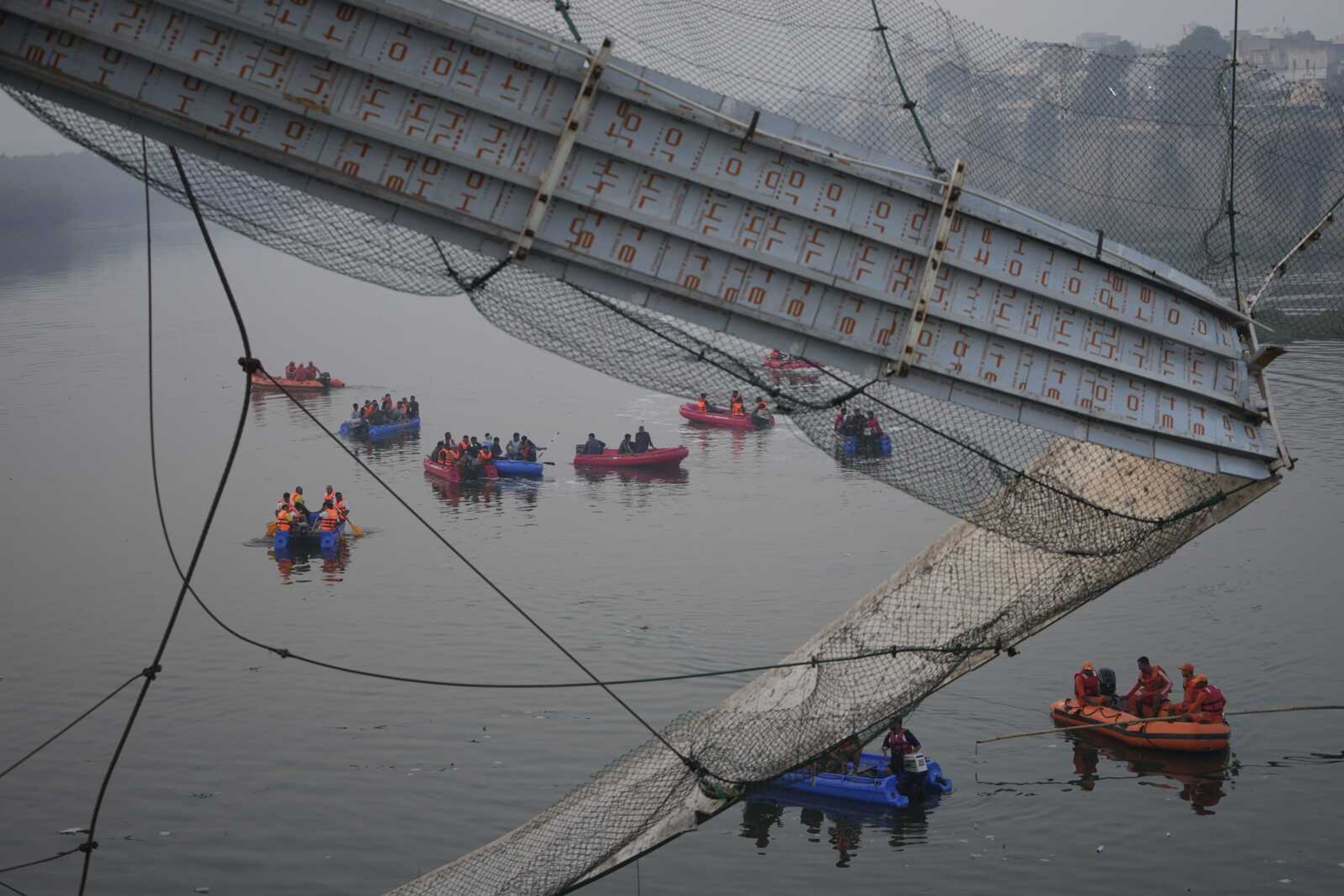 Rescuers on boats search in the Machchu river Monday next to a cable suspension bridge that collapsed in Morbi town of western state Gujarat, India. The century-old cable suspension bridge collapsed into the river Sunday evening, sending hundreds plunging in the water, officials said.