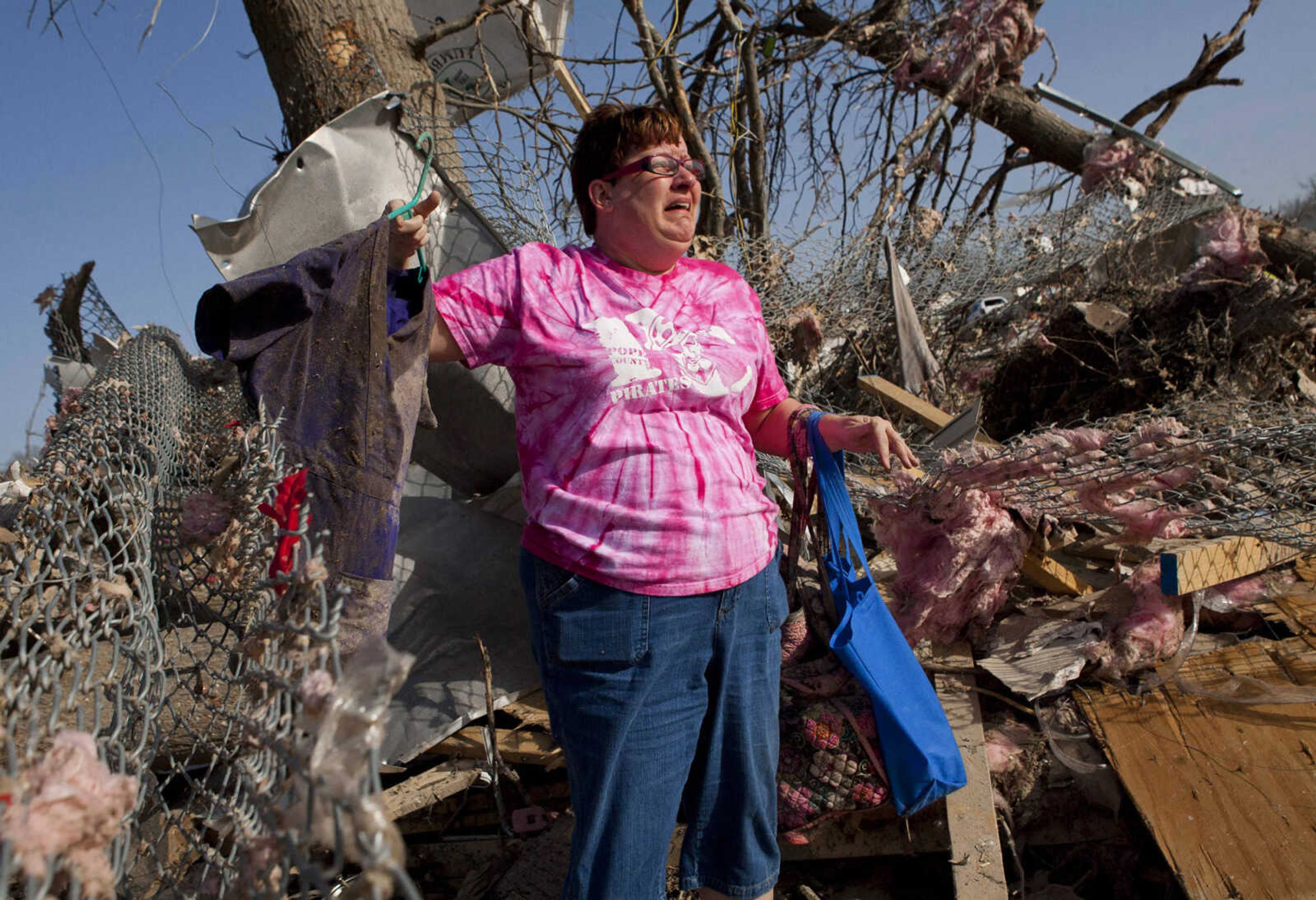 Patty Ferrell, of Herod, Ill., is overcome with emotion after finding the nursing scrubs that are on the hanger that belonged to her daughter, Jaylynn Ferrell, 22, who was killed in a tornado that struck Harrisburg, Ill., on Wednesday, Feb. 29, 2012.  The tornado destroyed the duplex where Jaylynn Ferrell had lived.    (AP Photo/The State Journal-Register/Justin L. Fowler)