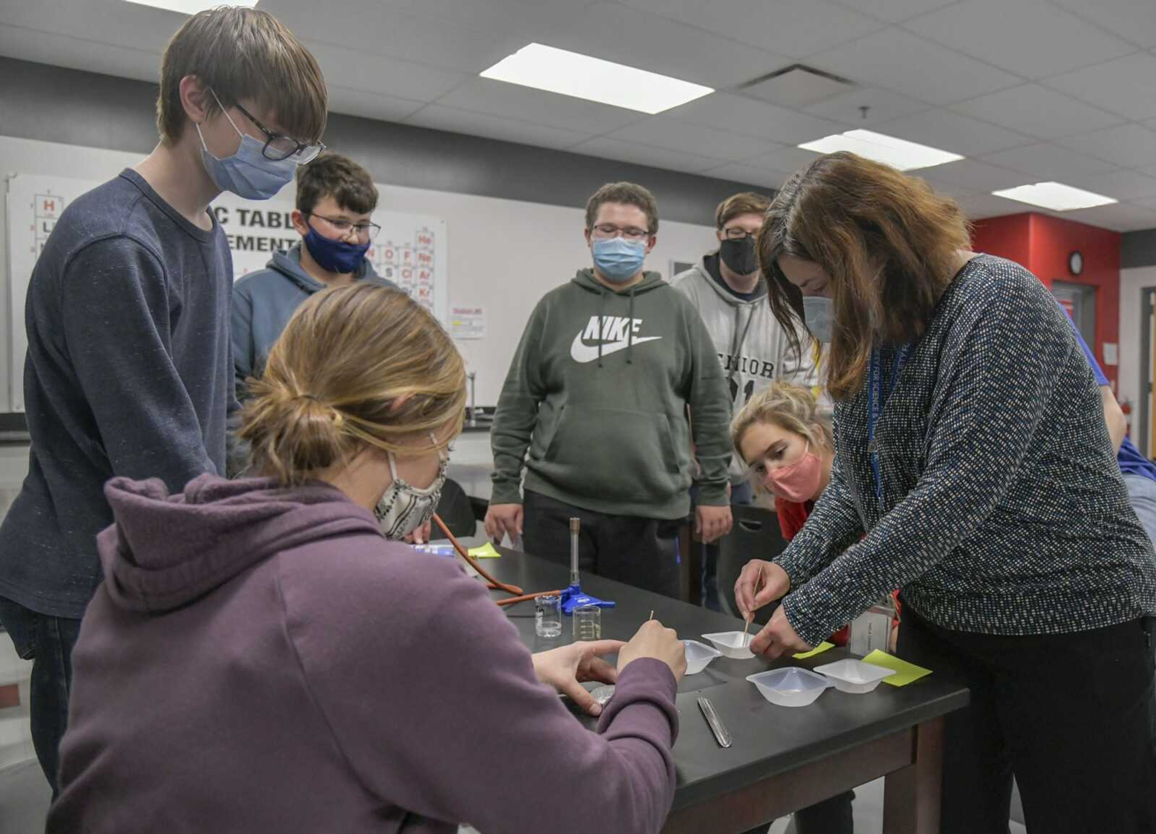 Students part of the Science Club and club advisor Leanne Thele, right, conduct an experiment together that solves a fictional mystery after school at Jackson Senior High School on Nov. 17, 2020.