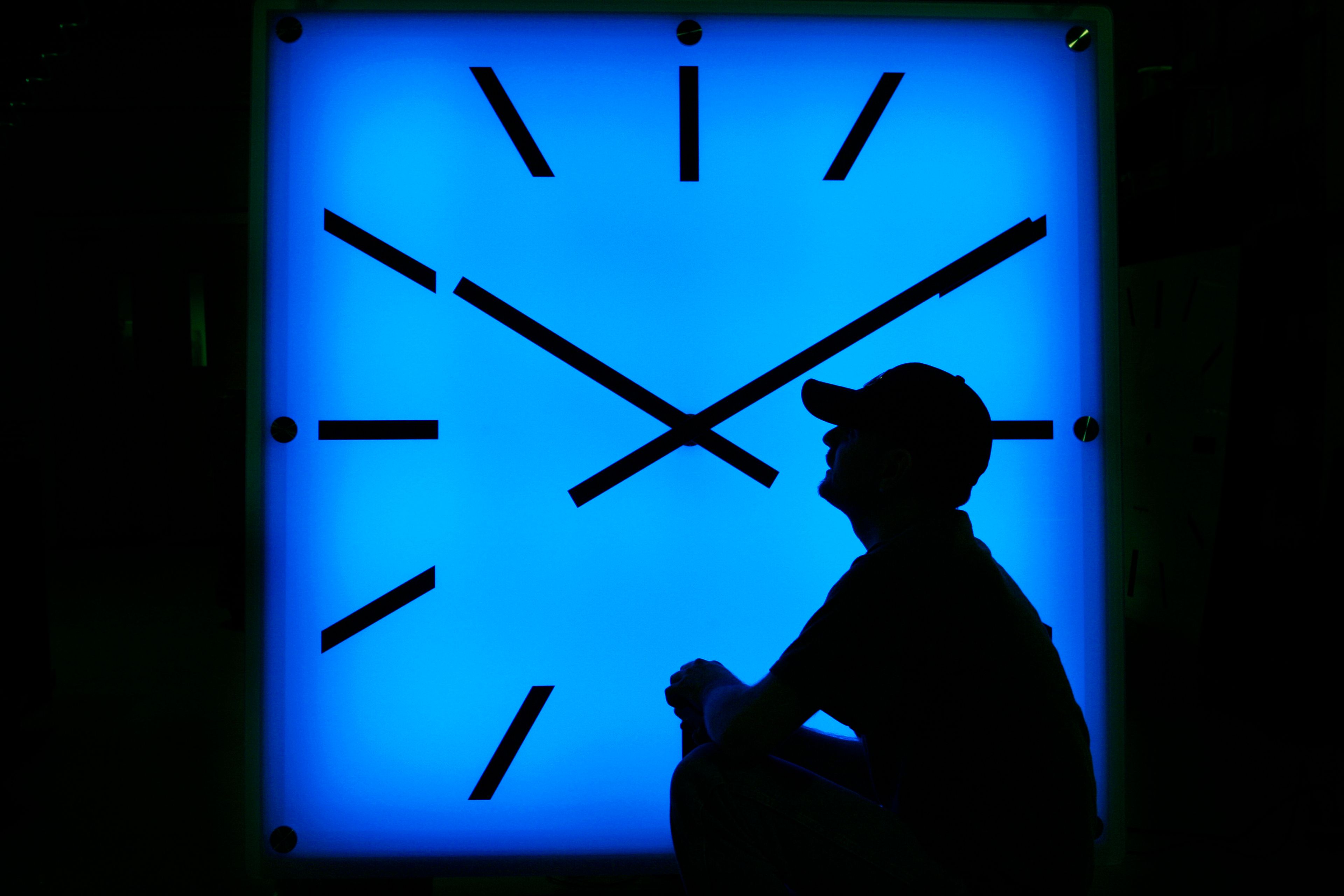 FILE - In this Oct. 30, 2008, file photo, an Electric Time Company employee adjusts the color on a clock at the plant in Medfield, Mass., days before the switch to standard time. (AP Photo/Elise Amendola, File)