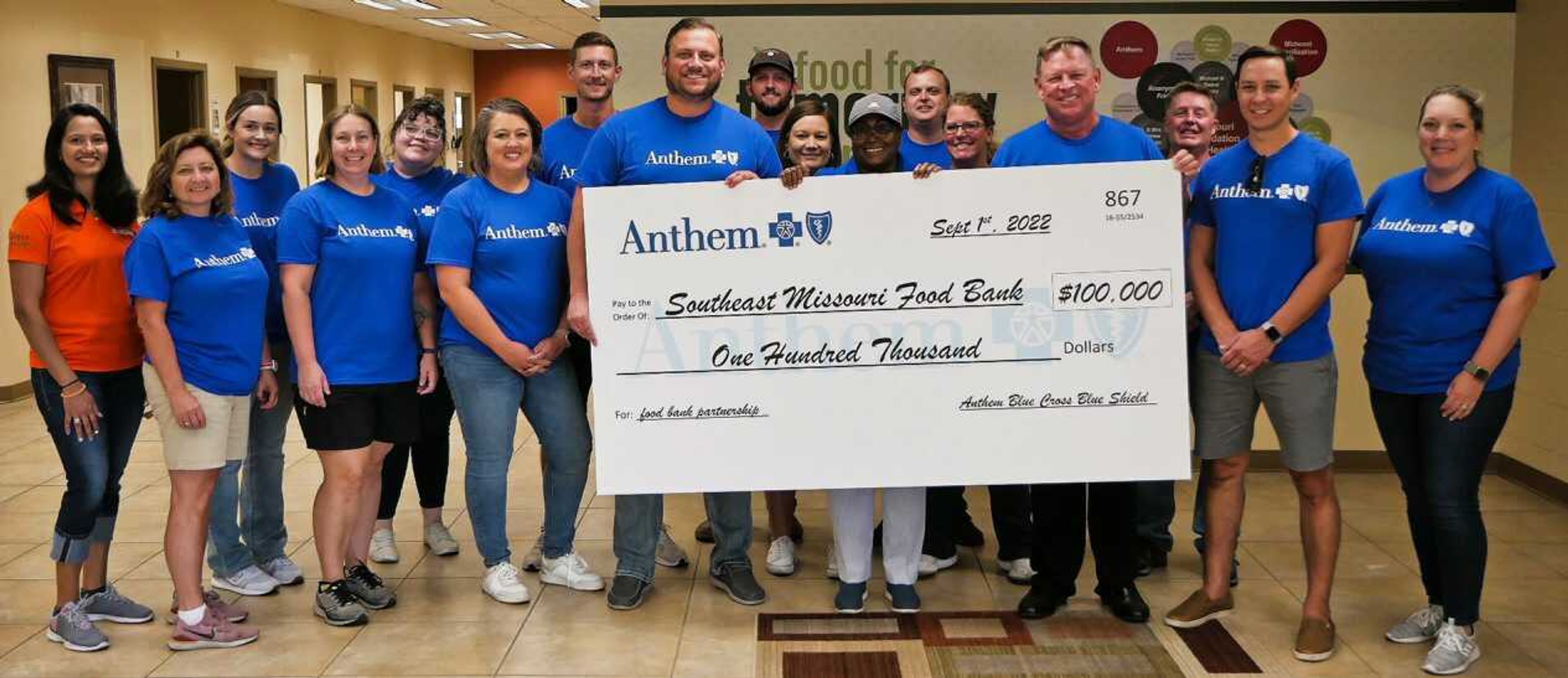 Joey Keys, SEMO Food Bank's executive director, on the left helping to hold the enlarged check, accepts a $100,000 gift Thursday from managed care company Anthem. Other food bank employees and Anthem representatives joined Keys for the presentation in Sikeston, Missouri.