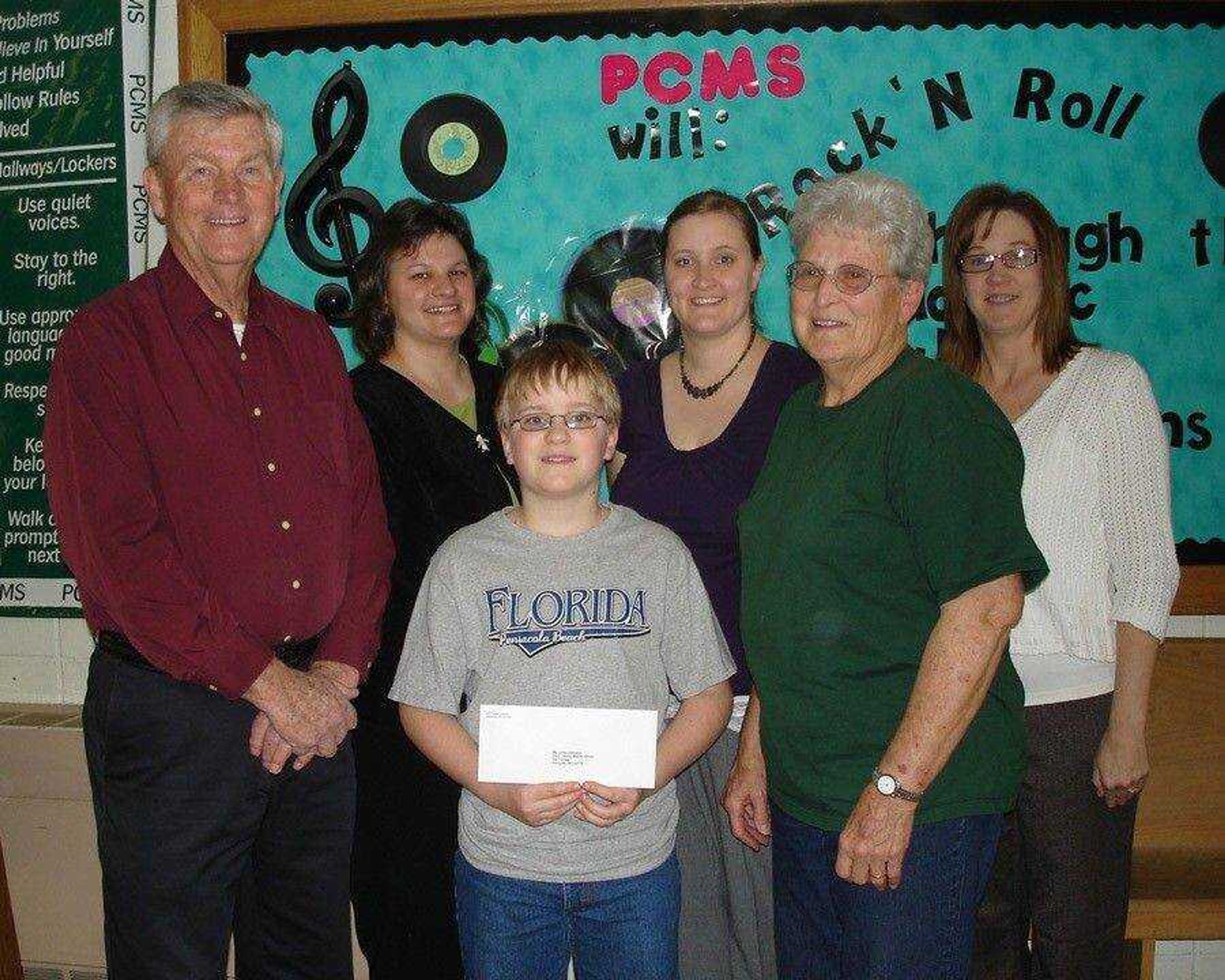 Accepting the donation from Kyle Brewer (center front) is PAWS President, Rick Schemel (left front).  Also present for the presentation were PAWS member Yvonne Romann (front right); and PCMS Teachers and BLAST Sponsors Candy Mueller (back left), Dana Beussink (center back), and Glenda Gremaud (back right). (Photo by L. Boxdorfer, Perry County School Dist. No. 32)