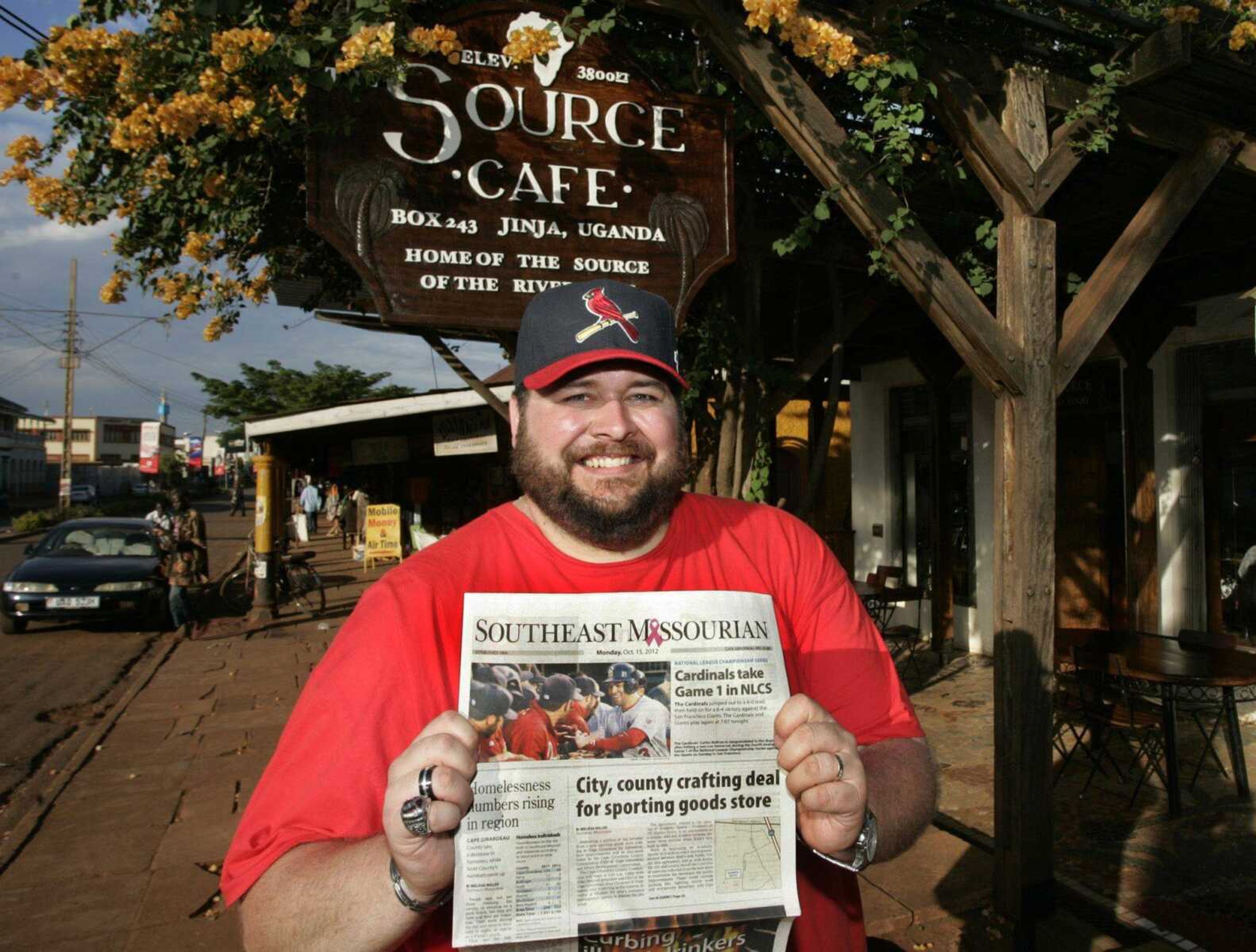 Advance Church of Christ preacher and Sikeston, Mo., resident Kyle Carter holds a copy of the Southeast Missourian in front of the Source Cafe on Main Street in Jinja, Uganda. Carter recently traveled on a mission trip to Jinja to work with the local churches of Christ and Kibo Group International. Carter worked in the city and villages along side resident missionaries Bobby and Candice Garner &#8212; all three are graduates of Dexter High School. (Submitted photo)