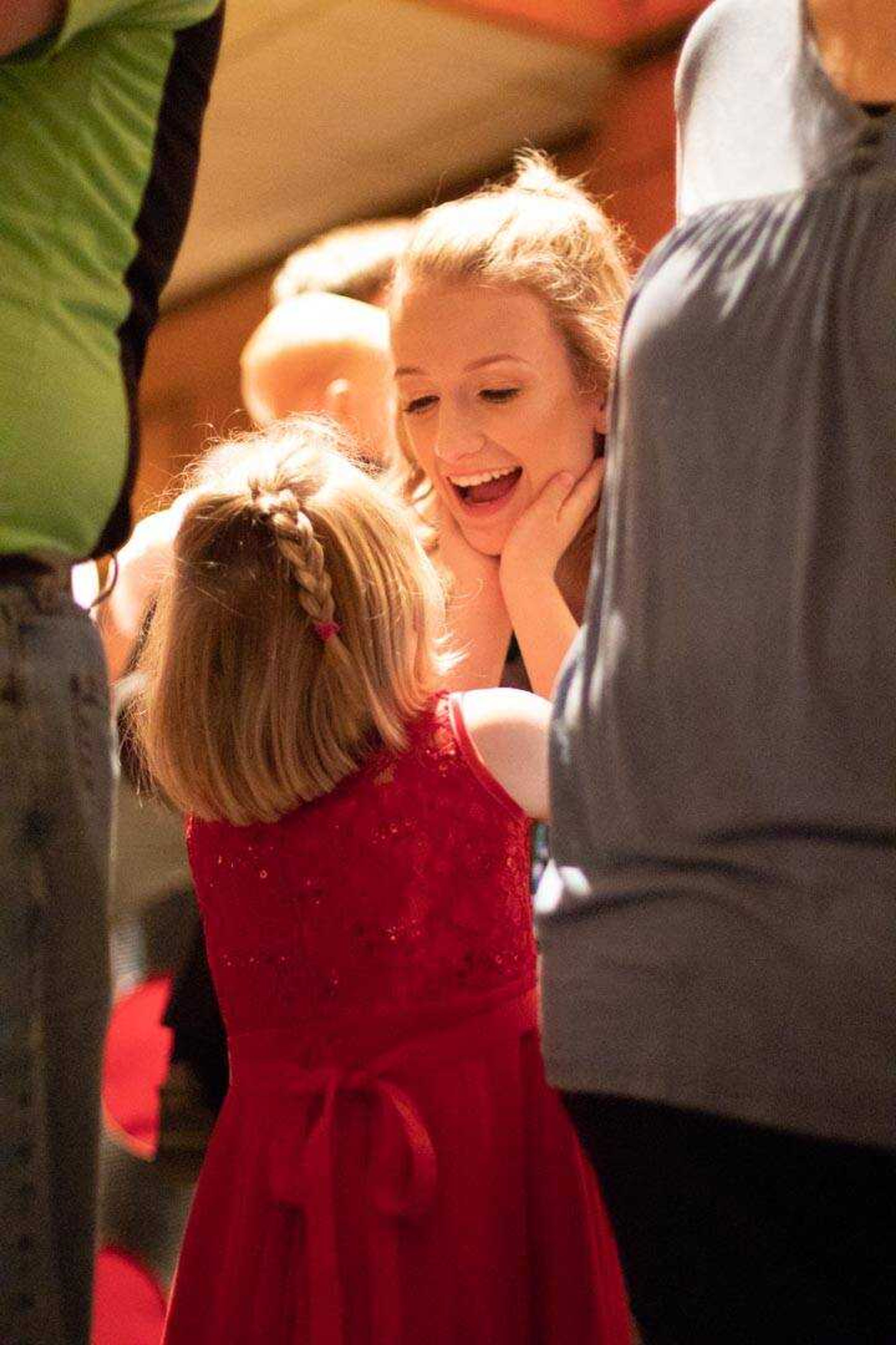 Claudia Lawrence, 8, gives her sister Sara Burch a kiss after the grand entrance at Chaffee High School's prom&nbsp;Saturday, April 6, 2019,&nbsp;at the University Ballroom.