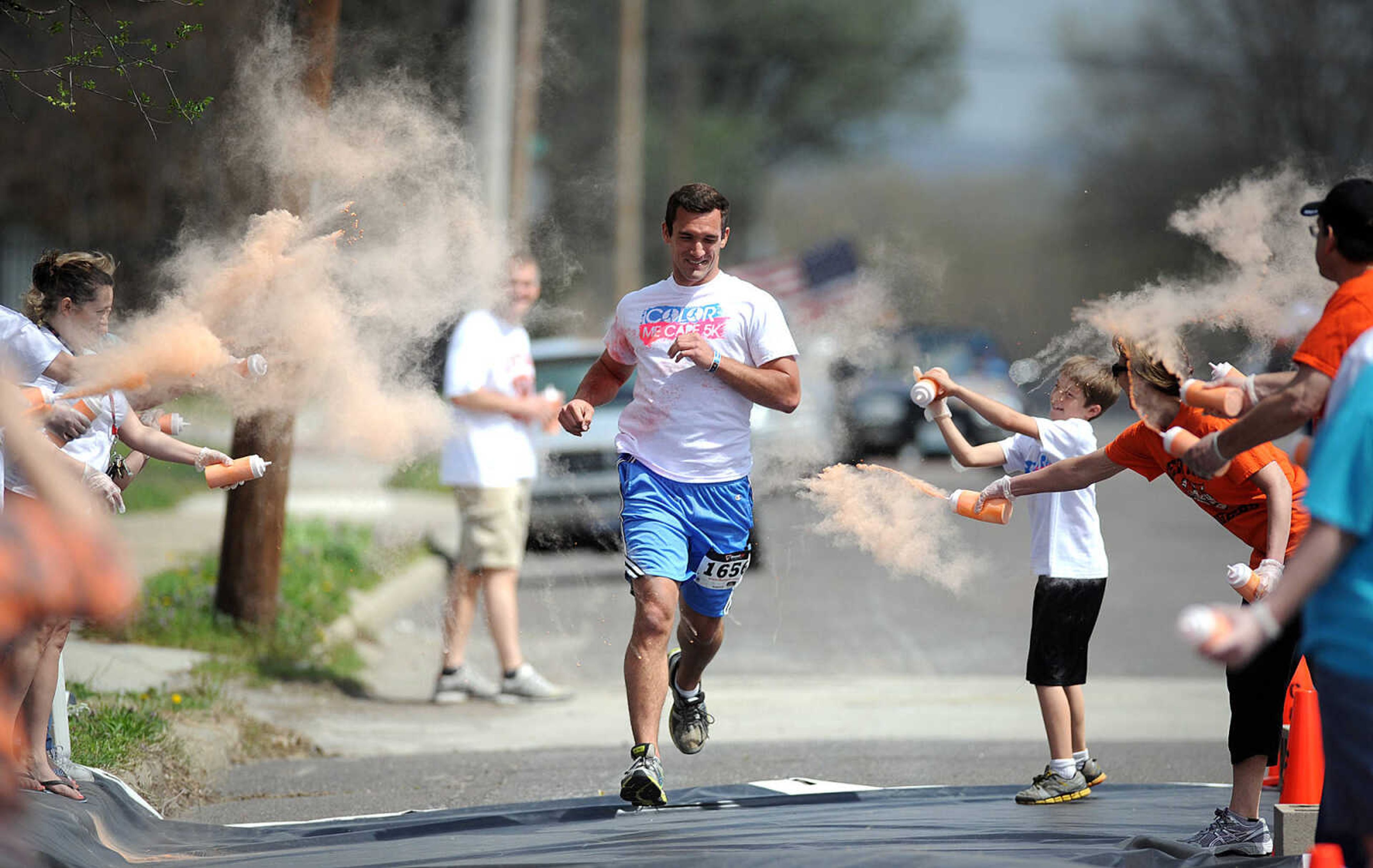 LAURA SIMON ~ lsimon@semissourian.com

Participants in the Color Me Cape 5K are sprayed with orange powder at the first color station on Good Hope Street, Saturday, April 12, 2014, in Cape Girardeau.