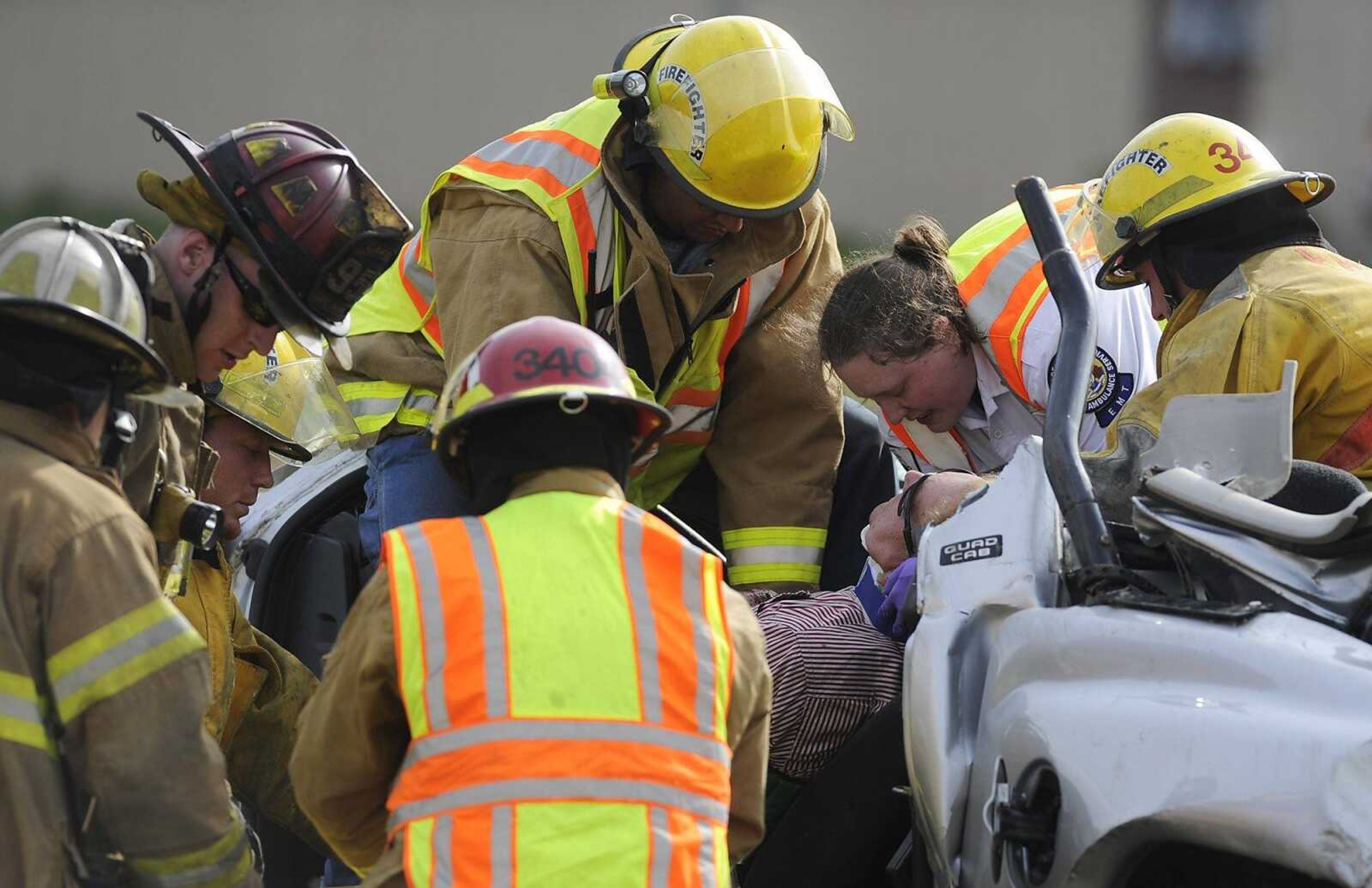 Emergency personnel work to remove an unidentified man from his truck after a two-vehicle accident on the northbound side of Interstate 55 near the 109 mile marker Wednesday. The Dodge truck, which was towing a trailer, rolled over into the median coming to rest on the cable barrier after colliding with a Toyota Corolla. (Adam Vogler)