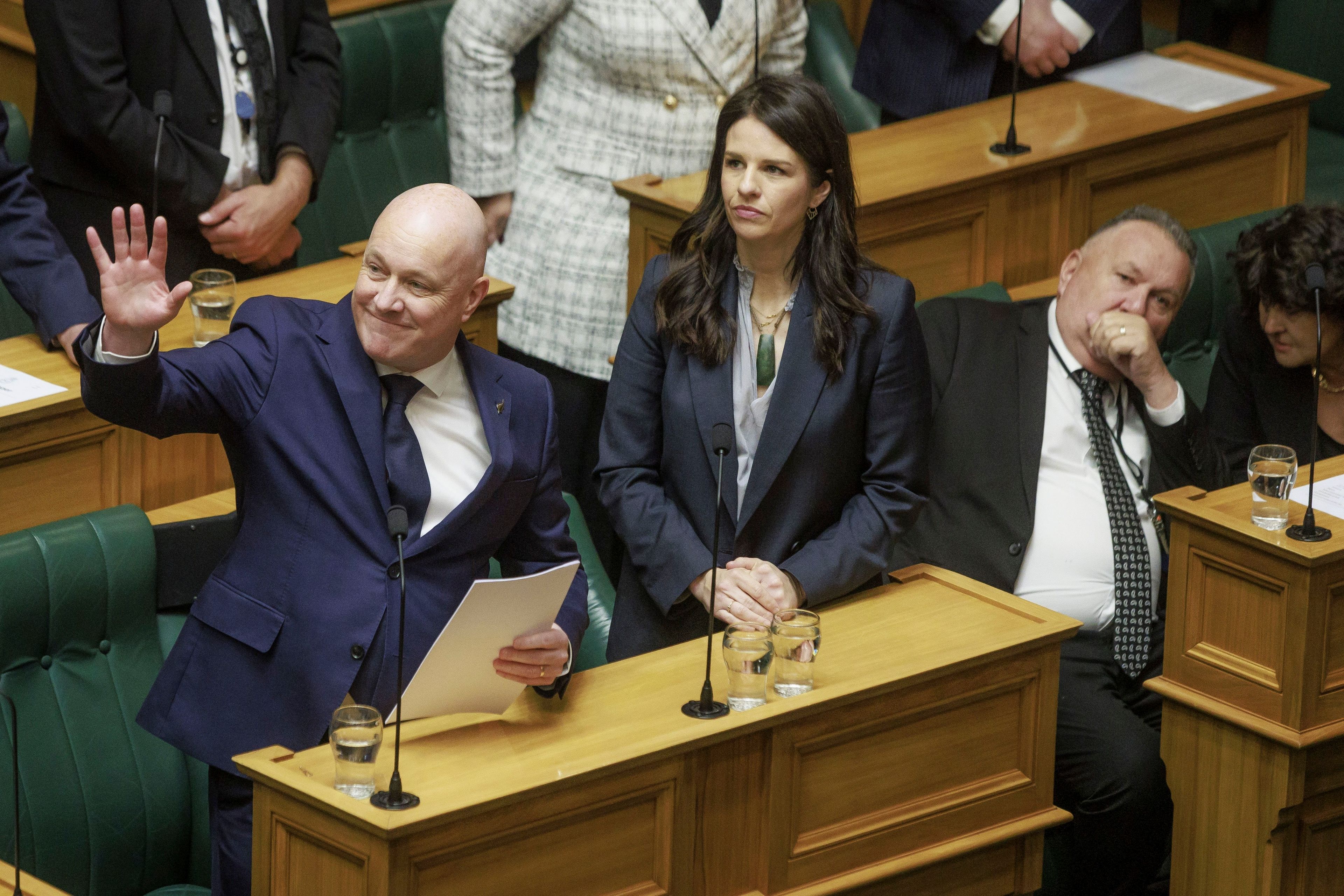 New Zealand's Prime Minister Christopher Luxon gestures to the public gallery as he makes a "formal and unreserved" apology in Parliament for the widespread abuse, torture and neglect of hundreds of thousands of children and vulnerable adults in care, in Wellington, New Zealand, Tuesday, Nov. 12, 2024. (Robert Kitchin/Stuff via AP)