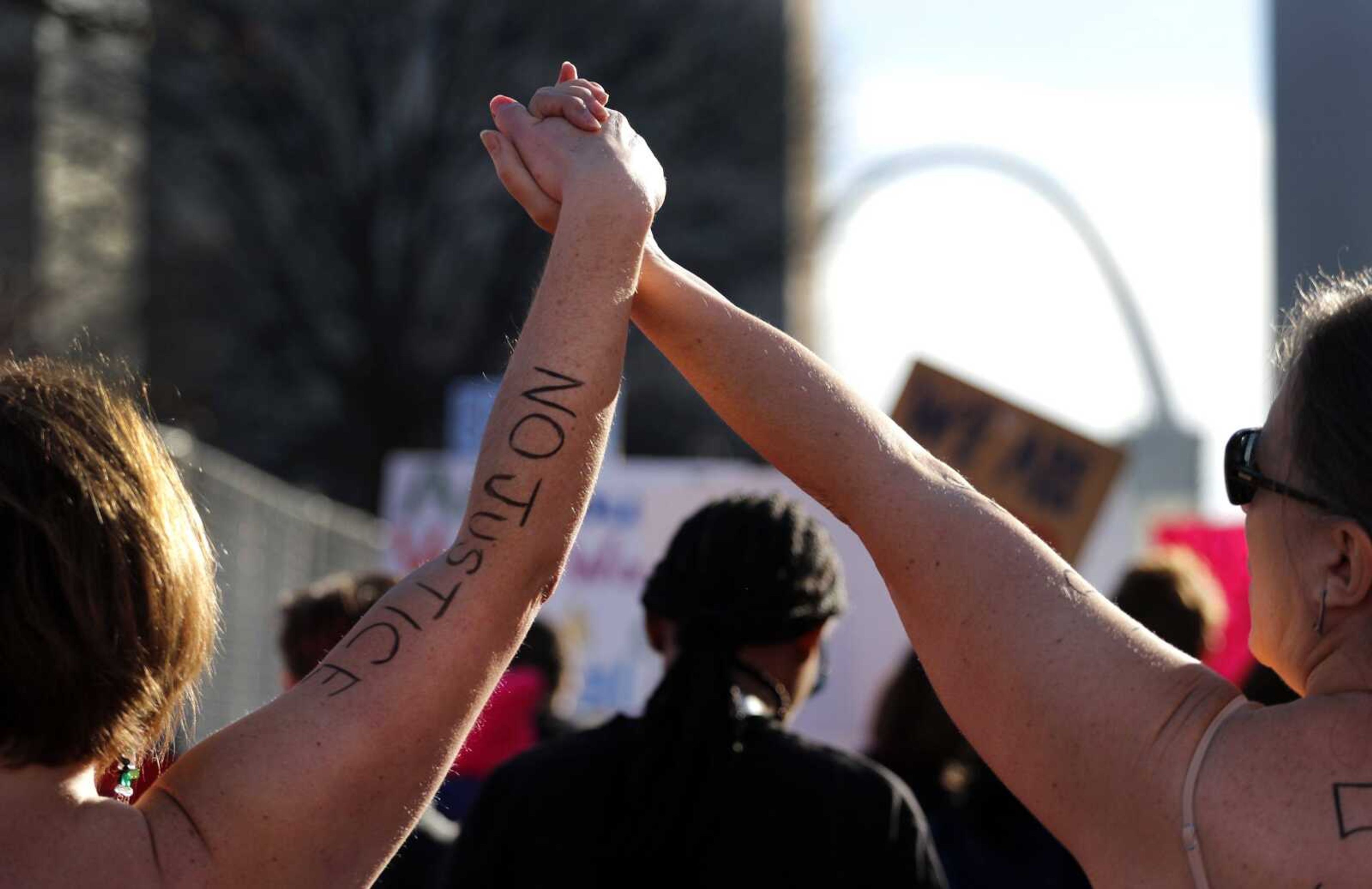 Women hold hands as they take part Saturday in a women's march in St. Louis.