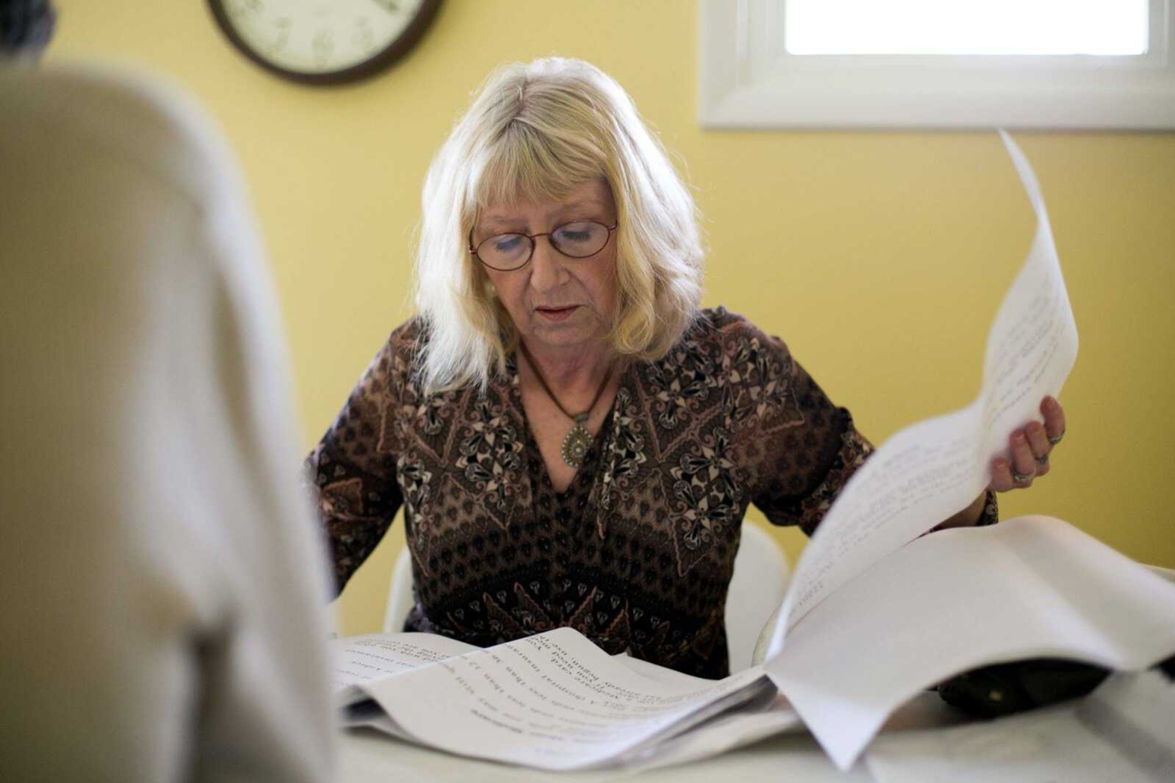 Carol Christopher reads disability documents to her brother, Paul King, on Thursday at Peaceful Pines Residential Care Facility in Poplar Bluff, Missouri.