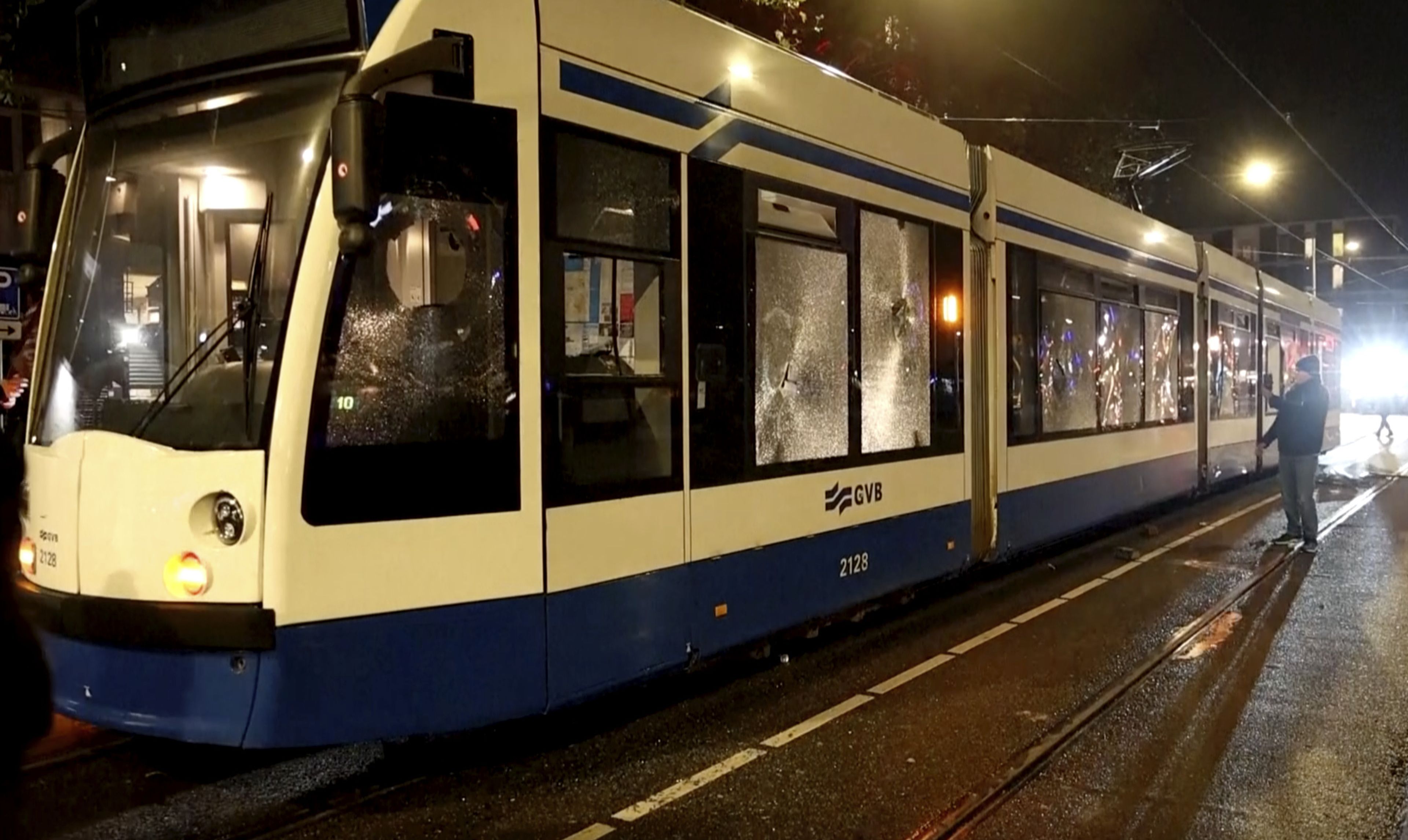 In this image taken from video, a person looks at a damaged tram in Amsterdam, Monday Nov. 11, 2024, as the city is facing tensions following violence last week. (AP Photo)