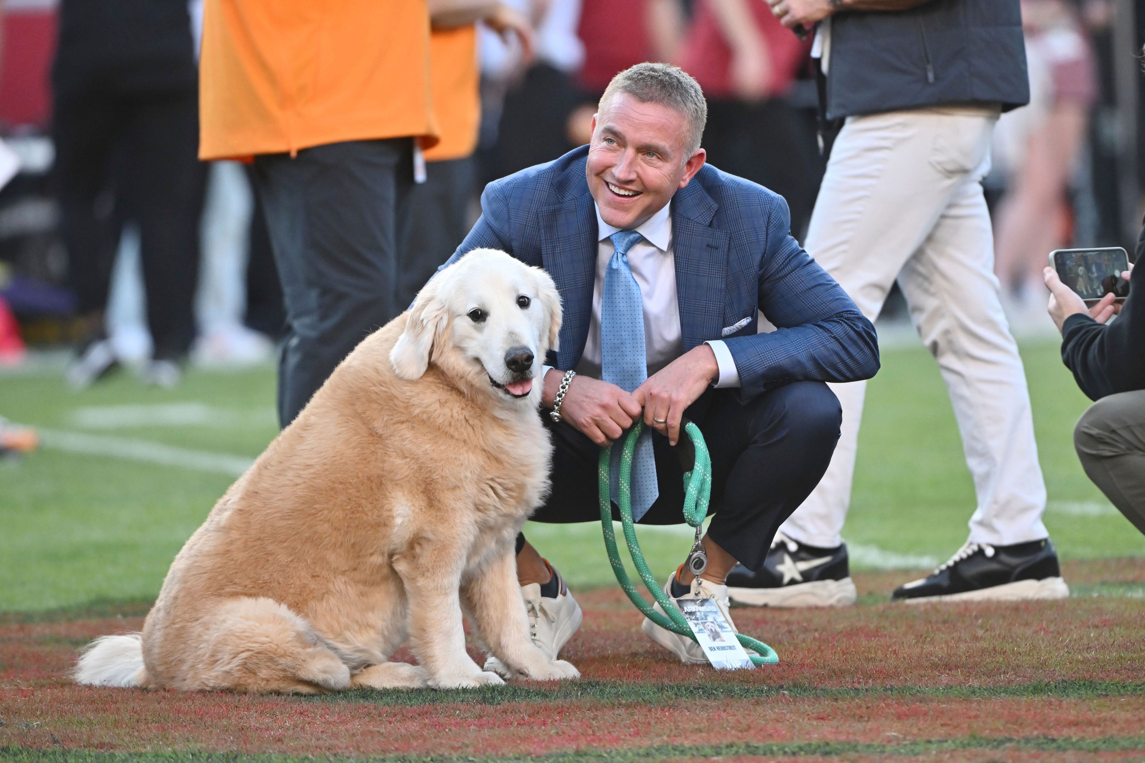 FILE - ESPN's Kirk Herbstreit and his dog Ben watch players warm up before the start of an NCAA college football game between Tennessee and Arkansas, Saturday, Oct. 5, 2024, in Fayetteville, Ark. (AP Photo/Michael Woods)