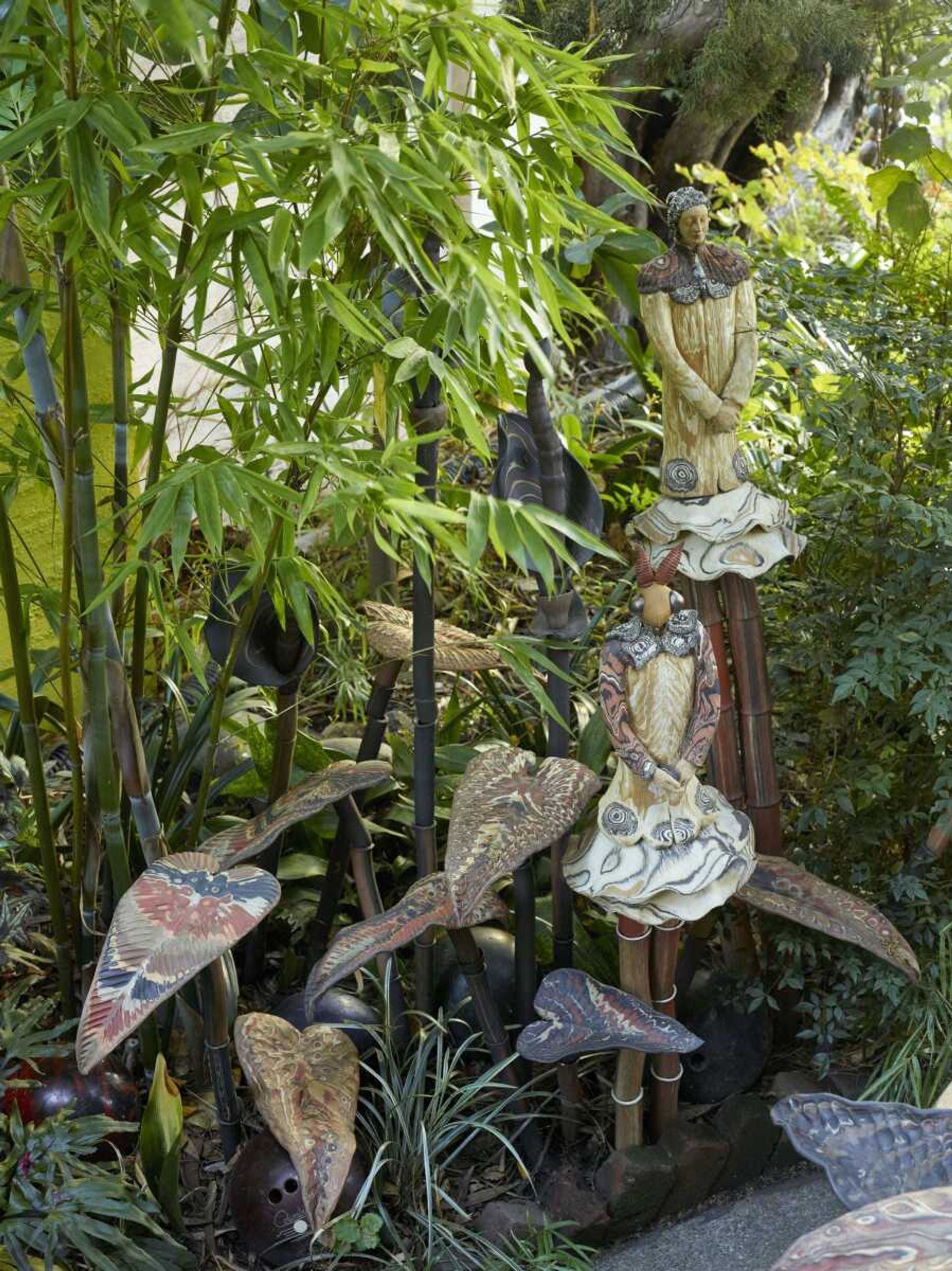 In this undated photo provided by The Monacelli Press, sprites and colorful leaf-shapes atop bamboo-like stems are interspersed with the plants in the Marcia Donahue Garden in Berkeley, California. The garden is featured in the book "Private Gardens of the Bay Area."