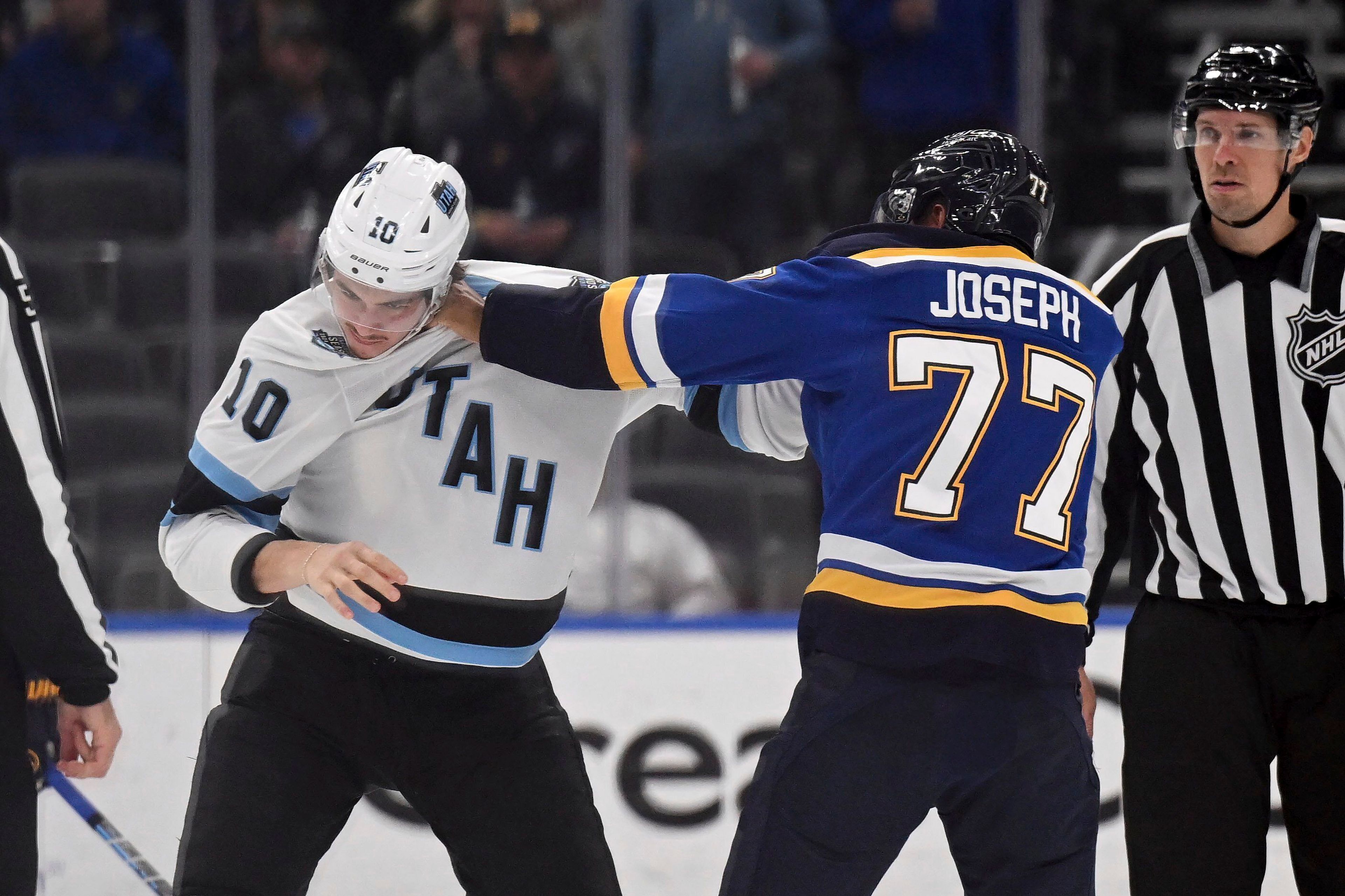 St. Louis Blues' Pierre-Olivier Joseph (77) gets physical with Utah Hockey Club's Maveric Lamoureux (10) during the second period of an NHL hockey game Thursday, Nov. 7, 2024, in St. Louis. (AP Photo/Connor Hamilton)