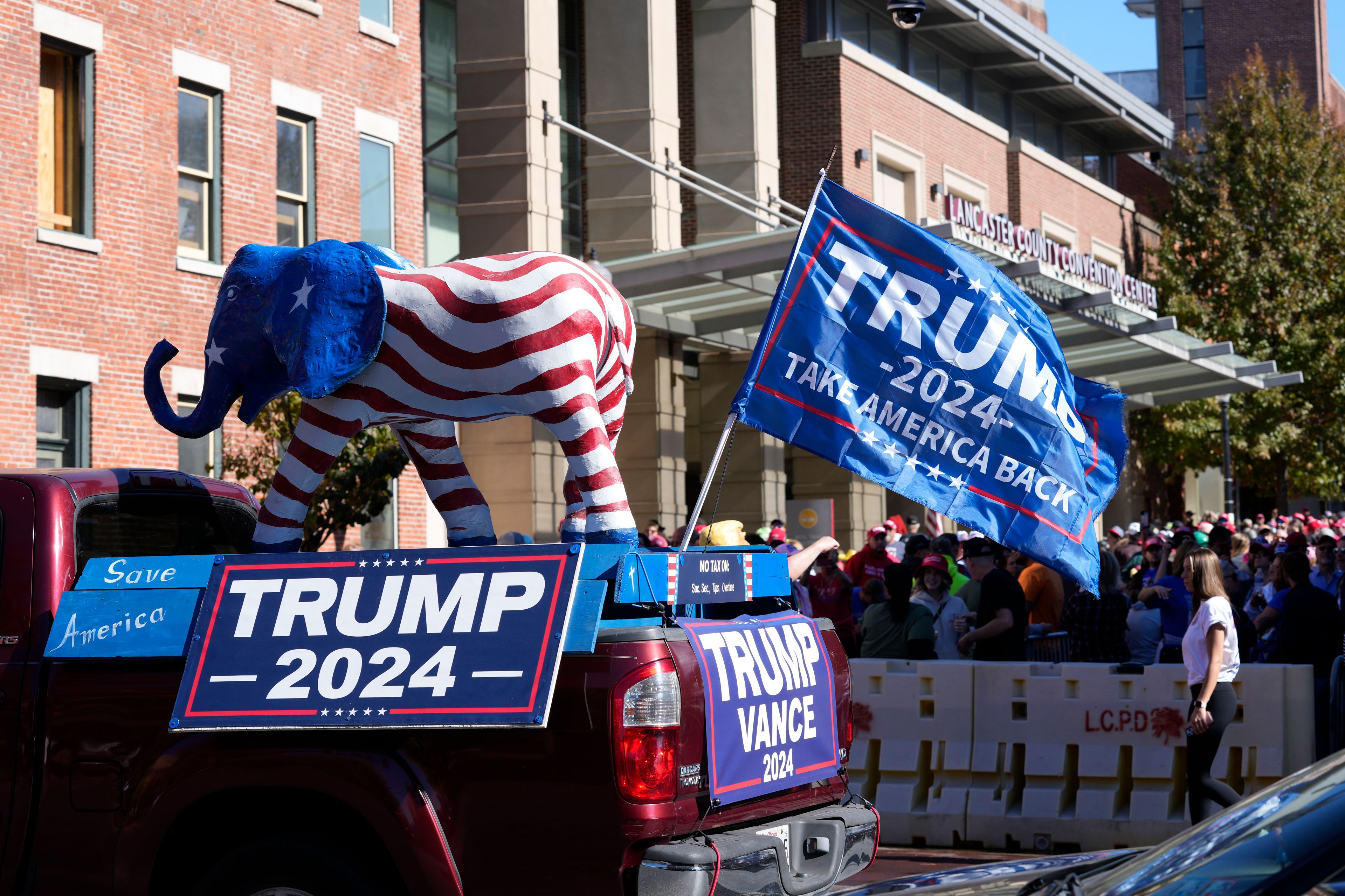 Supporters of Republican presidential nominee former President Donald Trump gather outside the Lancaster Convention Center in Lancaster, Pa., Sunday, Oct. 20, 2024, where Trump will hold a town hall. (AP Photo/Susan Walsh)