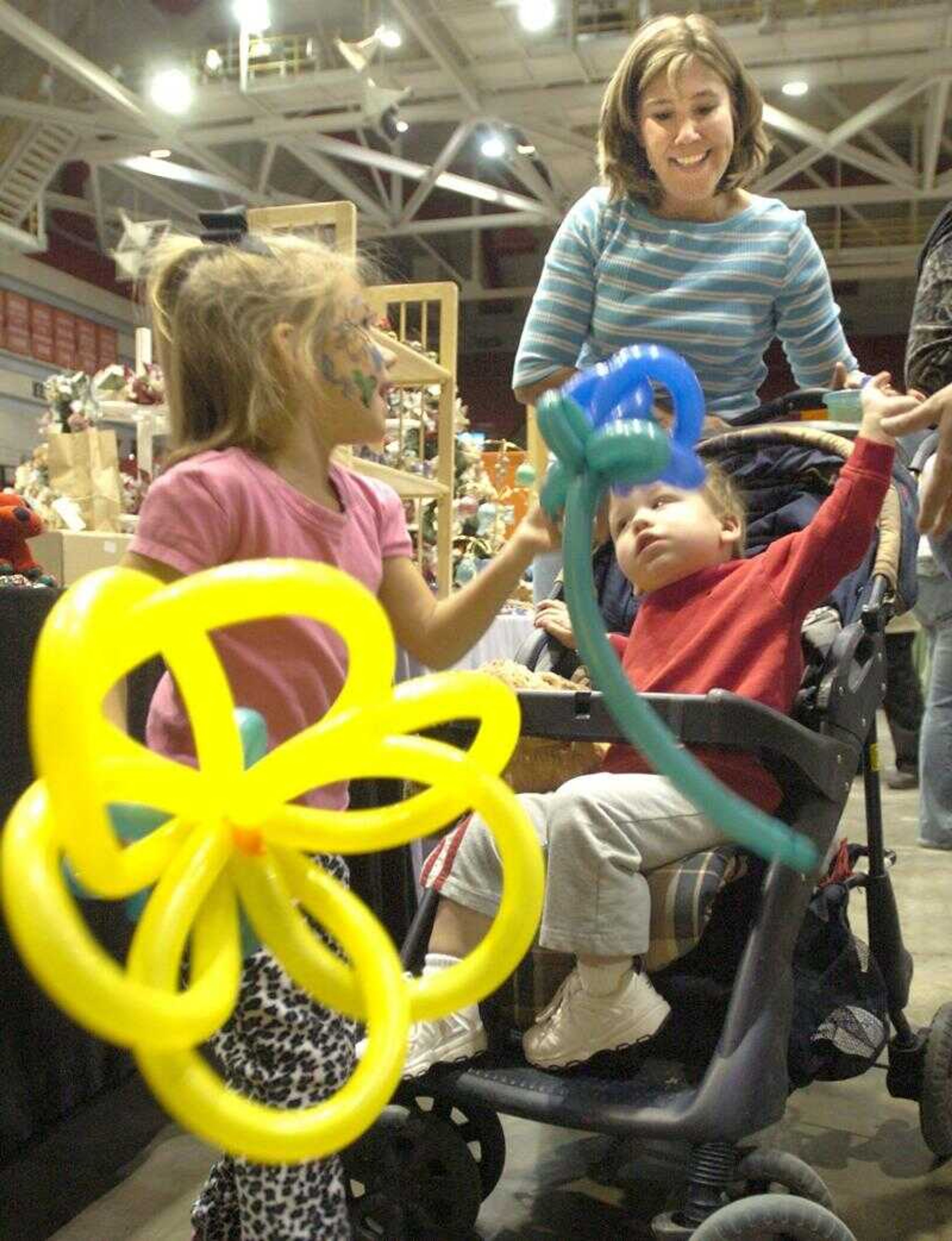 Julia Callow, 5, and her brother, Reece Callow, 18 months, had fun with balloon flowers along with their aunt Kandy Abner at the Christmas Arts and Crafts Extravaganza in the Show Me Center on Sunday. (Fred Lynch)