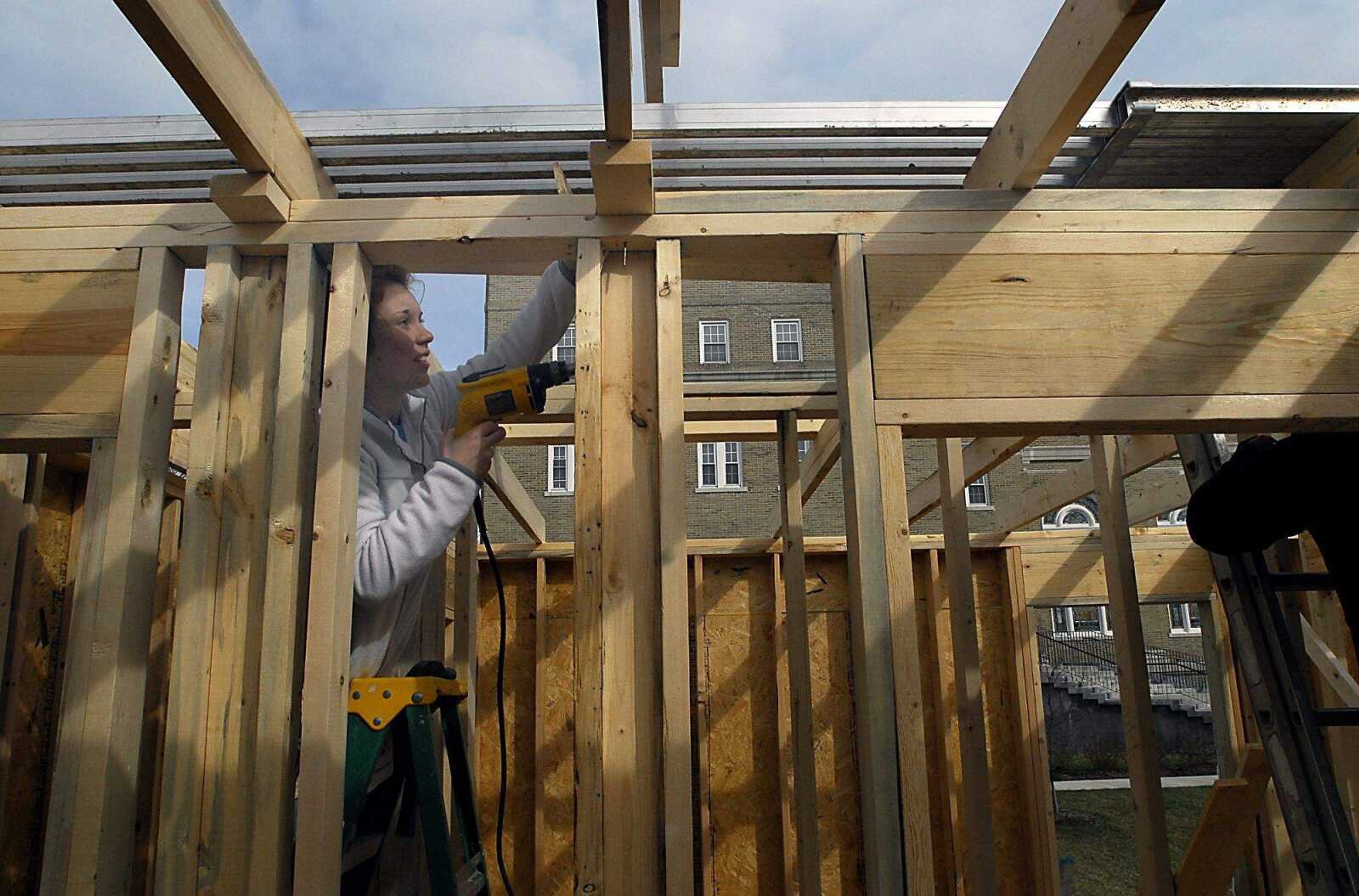 KIT DOYLE ~ kdoyle@semissourian.com
Nineteen-year-old volunteer Ann Leitensdorfer screws in ceiling beams at the Habitat for Humanity home being built in the Alumni Center parking lot Wednesday, March 11, 2009, in Cape Girardeau.