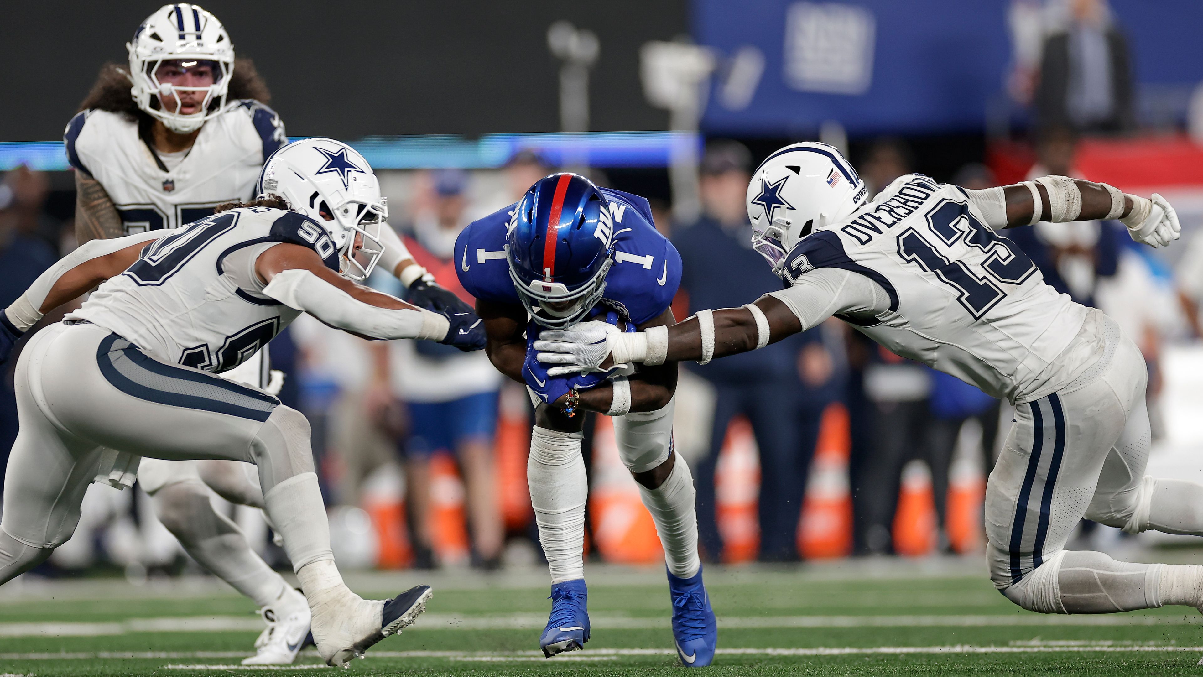 New York Giants wide receiver Malik Nabers (1) carries the ball against Dallas Cowboys linebacker DeMarvion Overshown (13) and linebacker Eric Kendricks (50) during the fourth quarter of an NFL football game, Thursday, Sept. 26, 2024, in East Rutherford, N.J. (AP Photo/Adam Hunger)