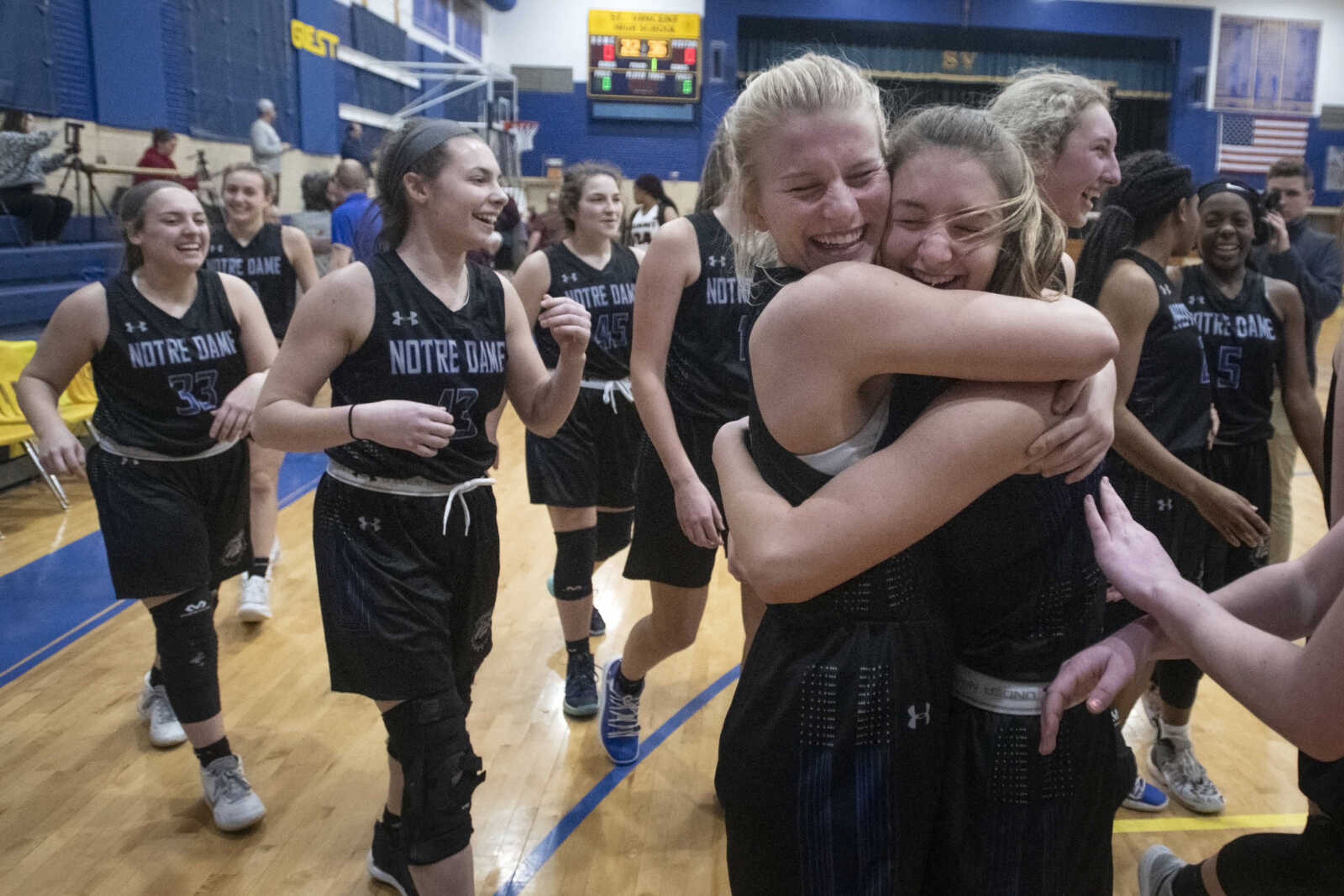 Notre Dame junior Allie Burnett (4), left in hug, embraces sophomore Leah Jansen (20) following Notre Dame's 55-35 victory against Rockwood Summit in the Class 4 quarterfinals Saturday, March 14, 2020, at St. Vincent High School in Perryville, Missouri.