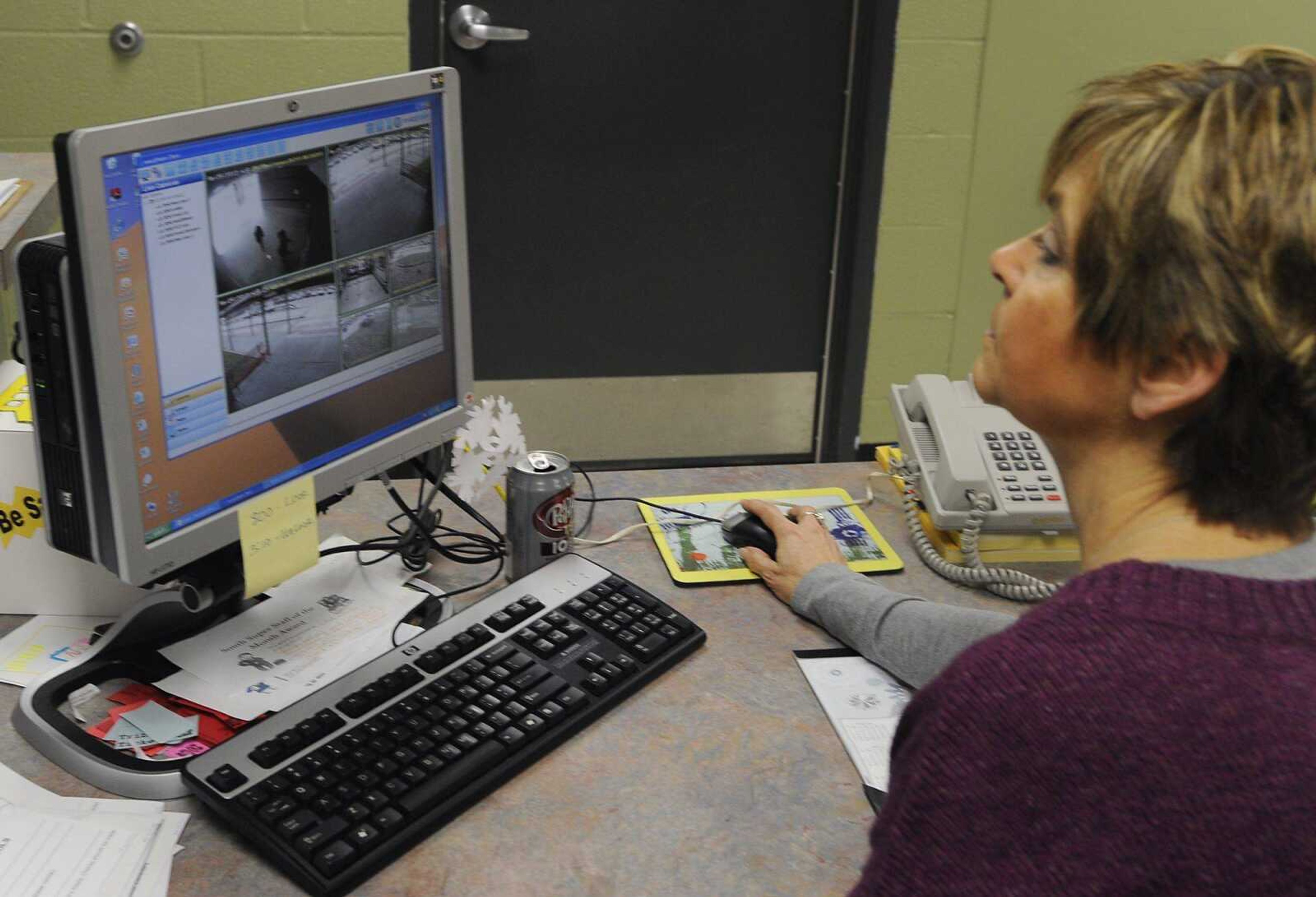 Secretary Cindi Crites watches as a parent and their child approach the front entrance of South Elementary School in Jackson. The school uses a camera and intercom system at the front entrance to identify anyone seeking to gain entry into the building. (ADAM VOGLER)