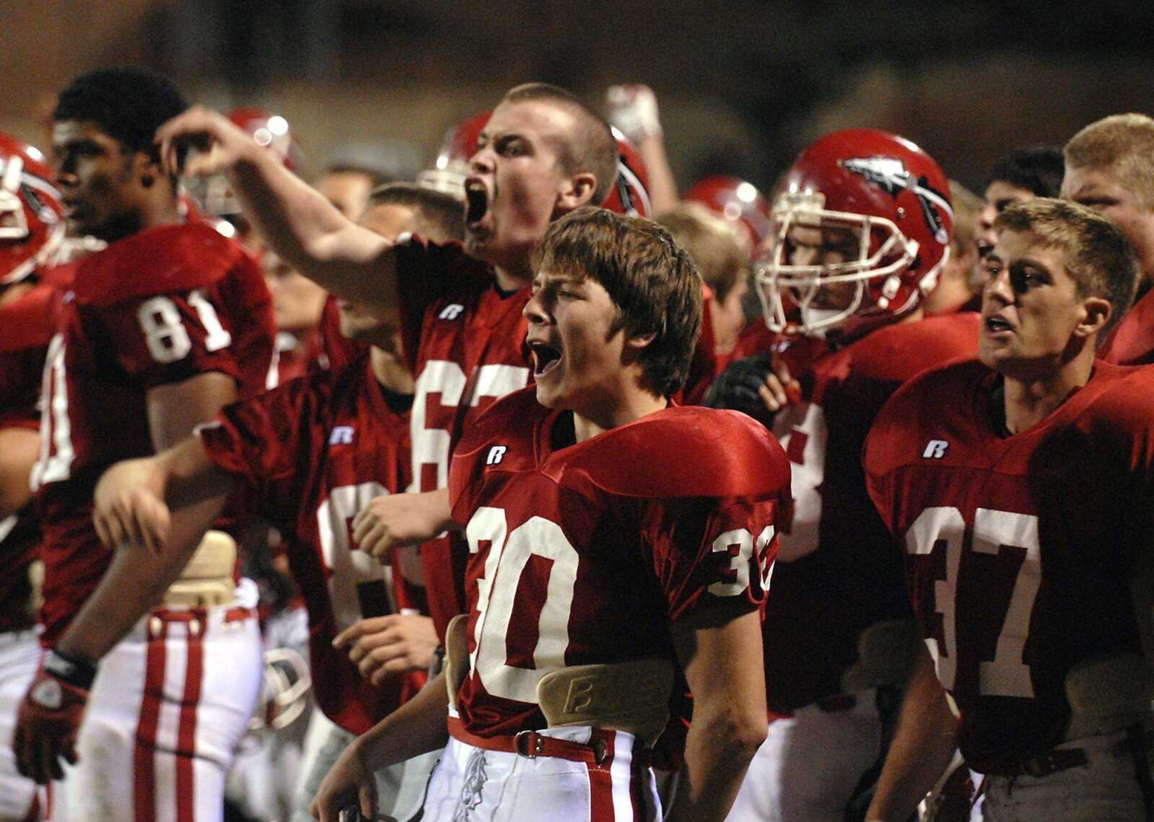 LEFT: Jackson players on the sideline cheer after the Indians scored a touchdown in the third quarter against Farmington. RIGHT: Jackson's Mitchell McCulley picks up yardage during the second quarter.